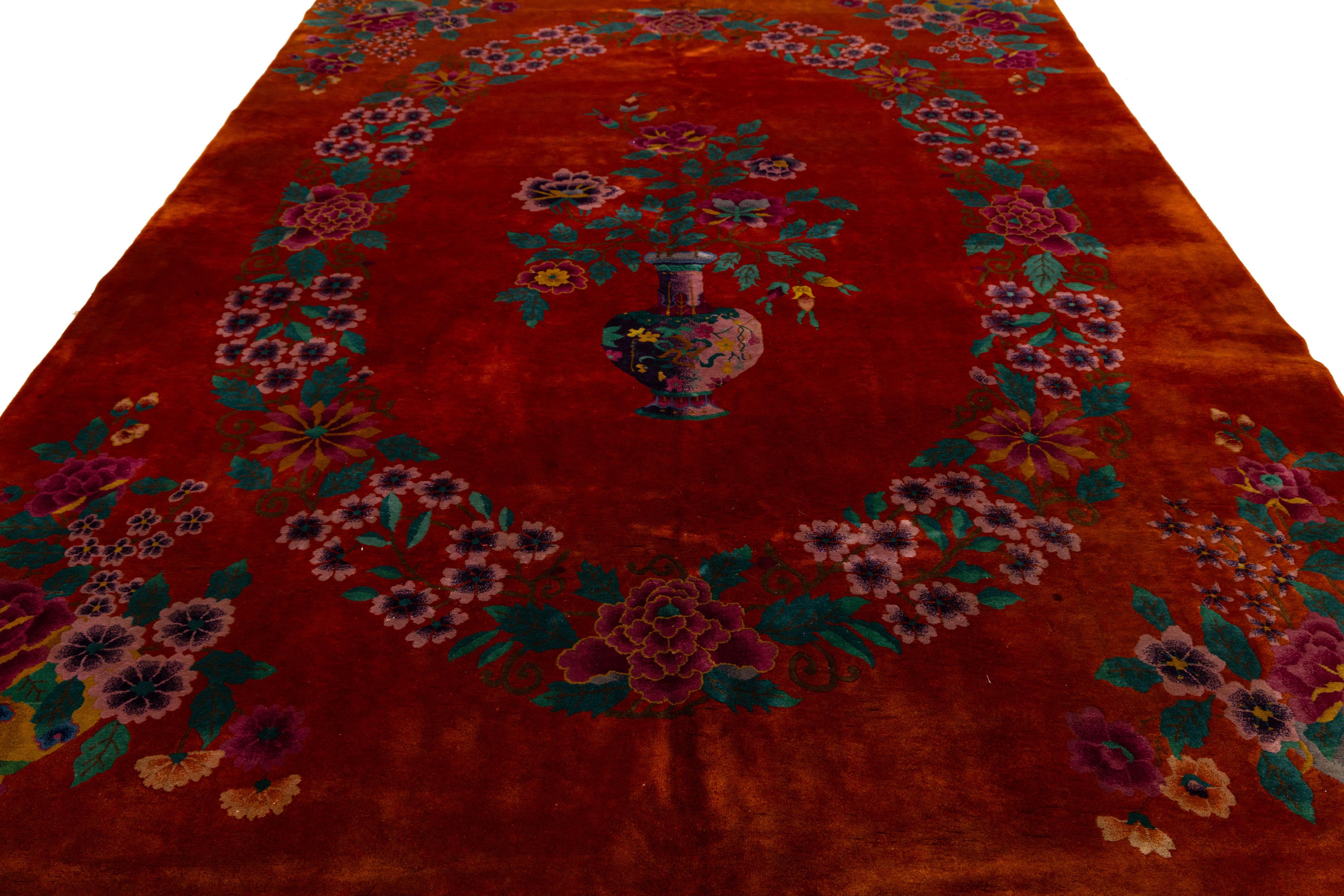 Magnifique tapis chinois antique Art Deco en laine nouée à la main avec un champ rouge. Ce tapis chinois présente des accents verts, roses et bleus dans un magnifique motif floral traditionnel chinois. 

Ce tapis mesure : 8'9
