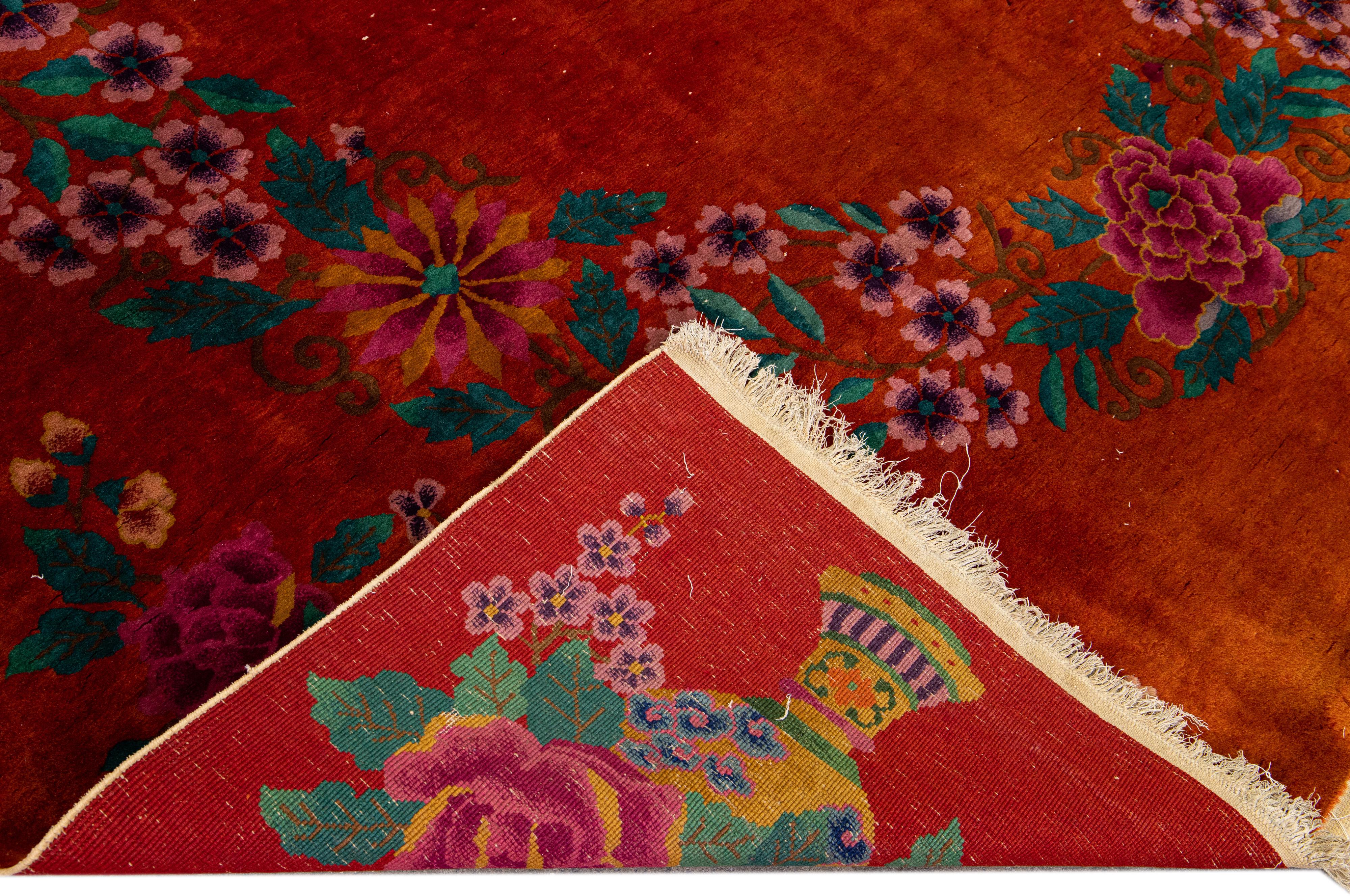 Beautiful antique Art Deco Chinese hand-knotted wool rug with a red field. This Chinese rug has green, pink, and blue accents in a gorgeous all-over traditional Chinese floral design. 

This rug measures: 8'9