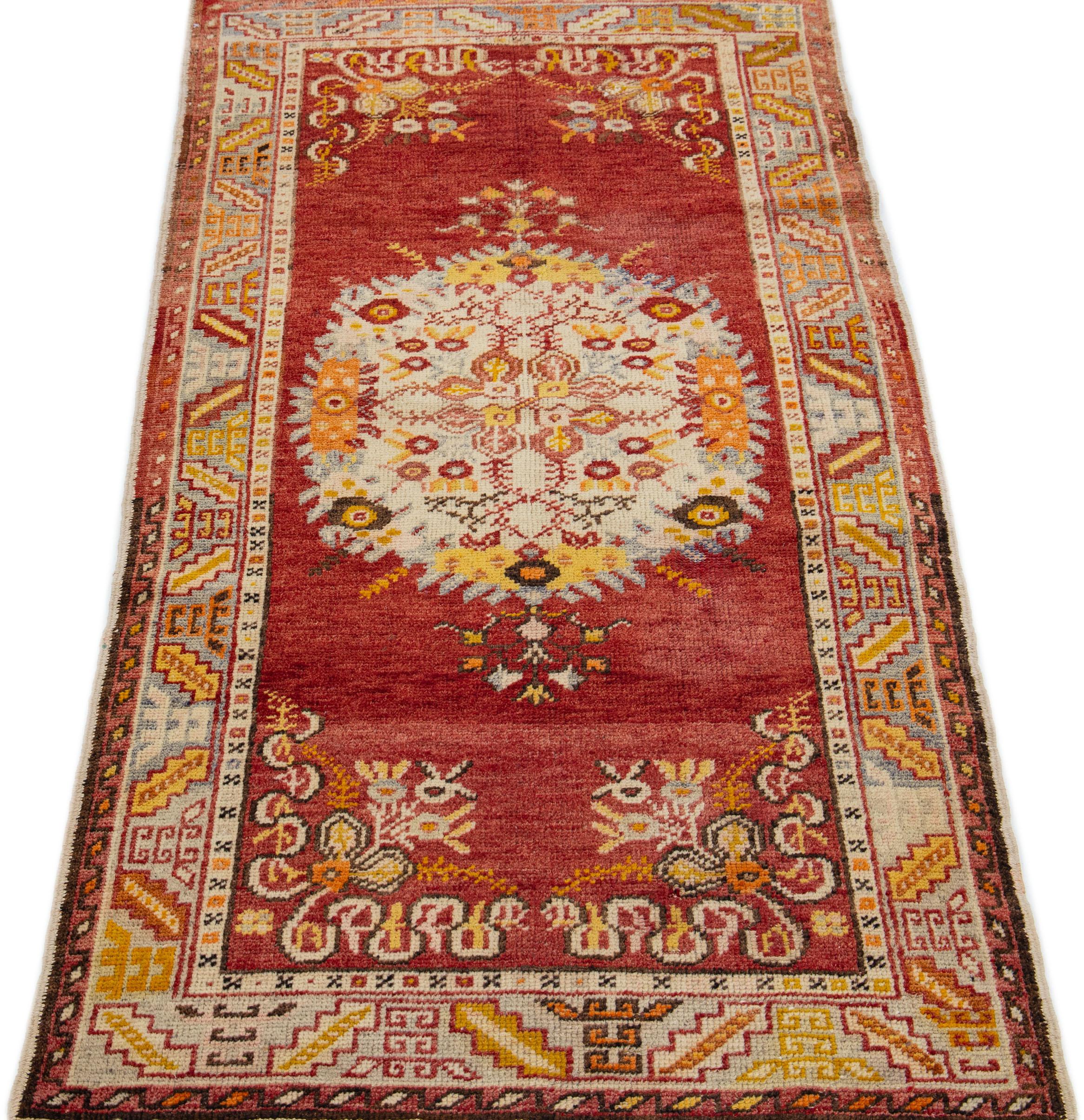 This 20th century Khotan rug is an antique piece featuring a red field and center medallion adorned with multicolor accents.

This rug measures 2'11