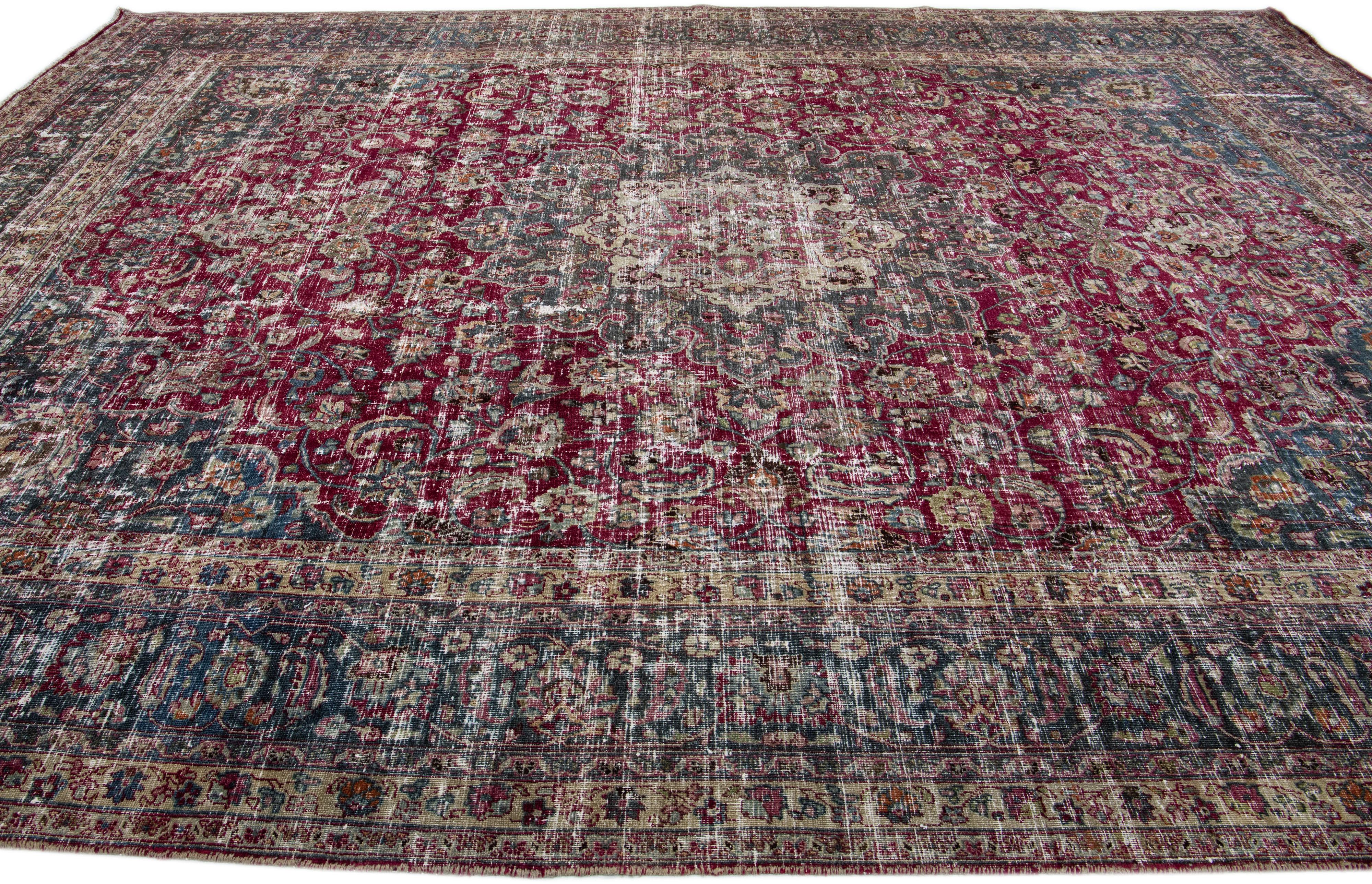 Noué à la main Tapis rouge en laine persane Mashad ancien fait à la main avec motif de rosettes en vente