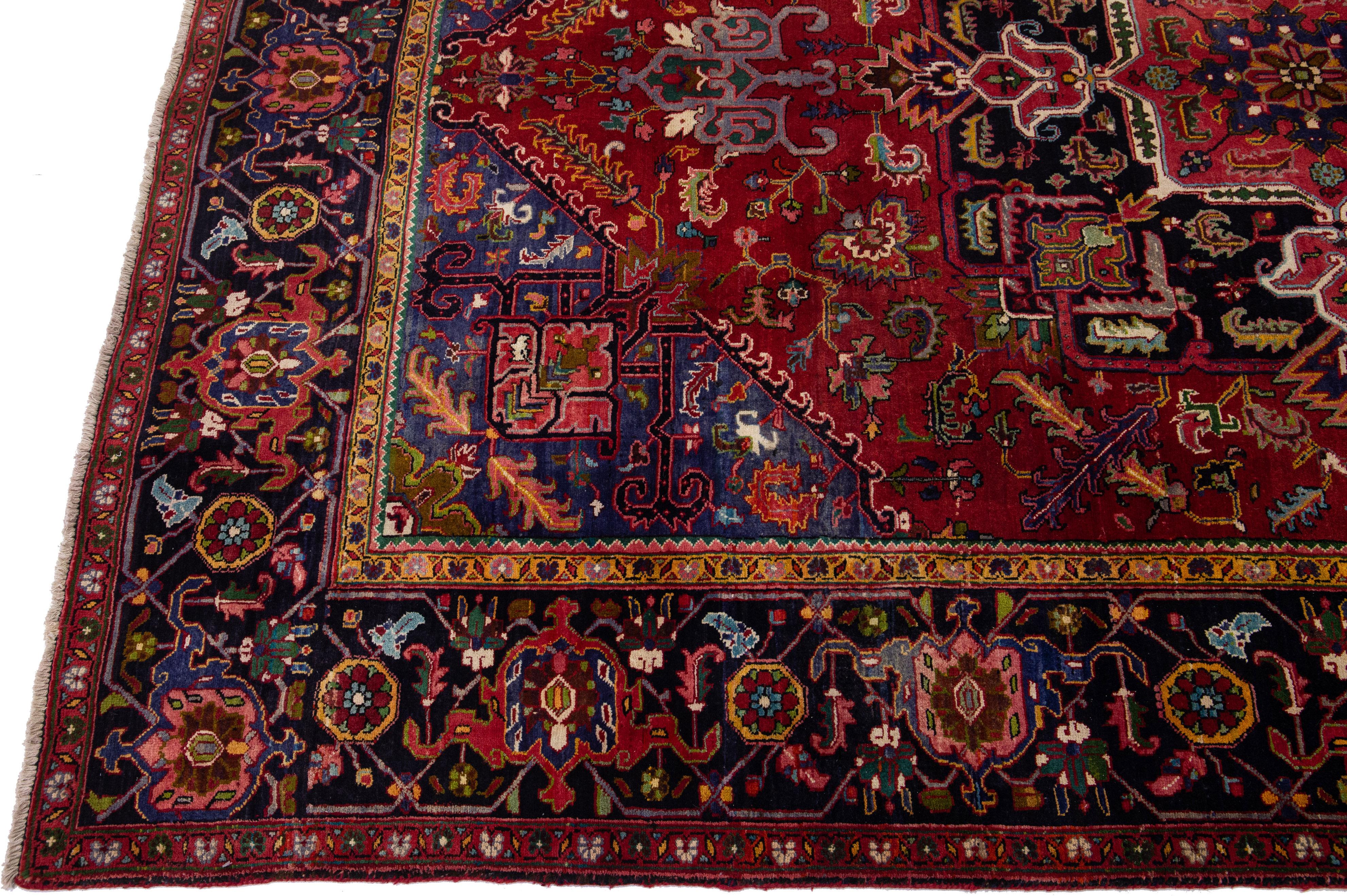 Beautiful antique Heriz hand-knotted wool rug with a red color field. This Persian rug has multicolor accents in a gorgeous all-over floral pattern.

This rug measures: 8'2