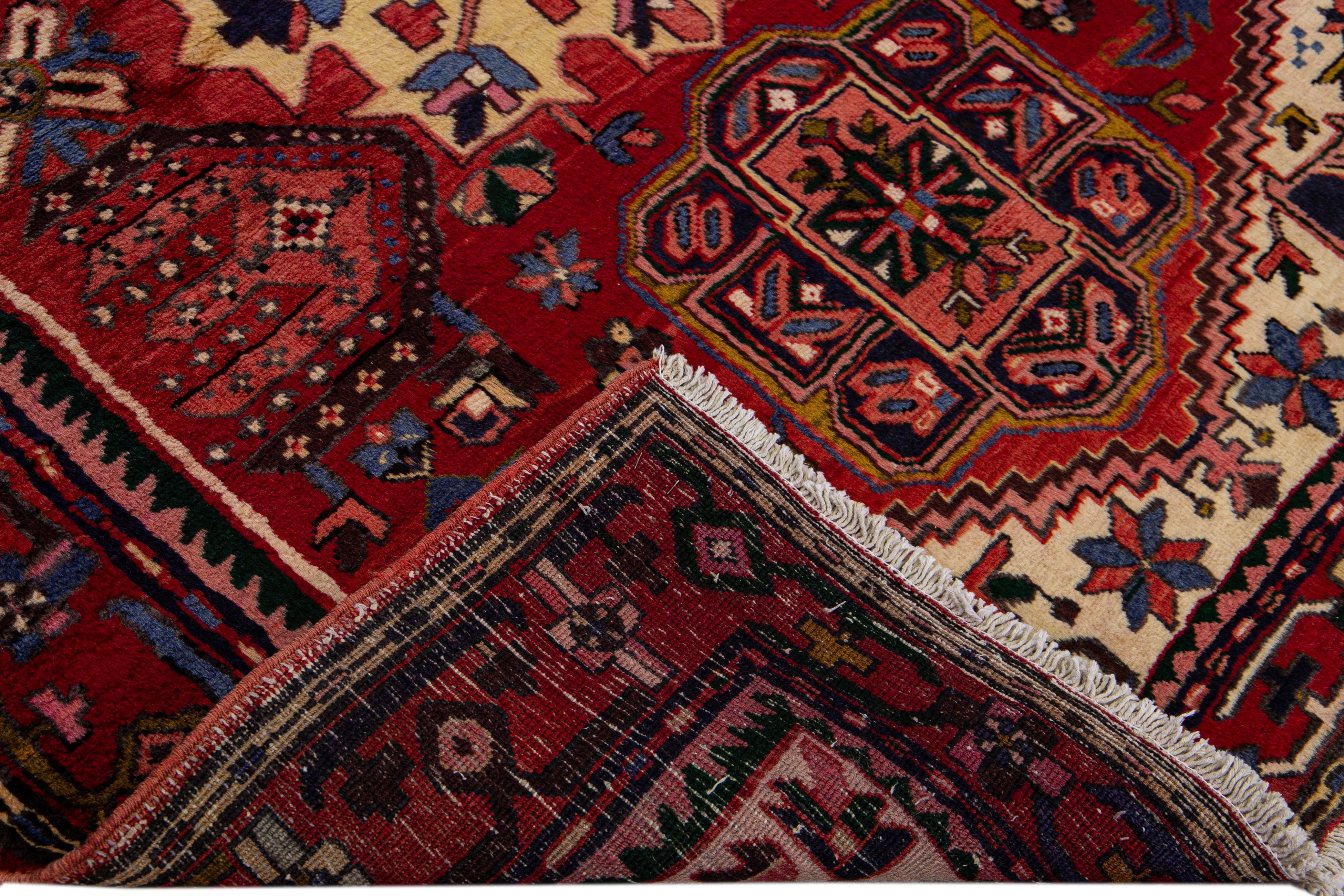 Beautiful antique Heriz hand-knotted wool rug with a red field. This Persian rug has a designed frame and multicolor accents in a gorgeous all-over geometric medallion floral motif.

This rug measures: 4'11