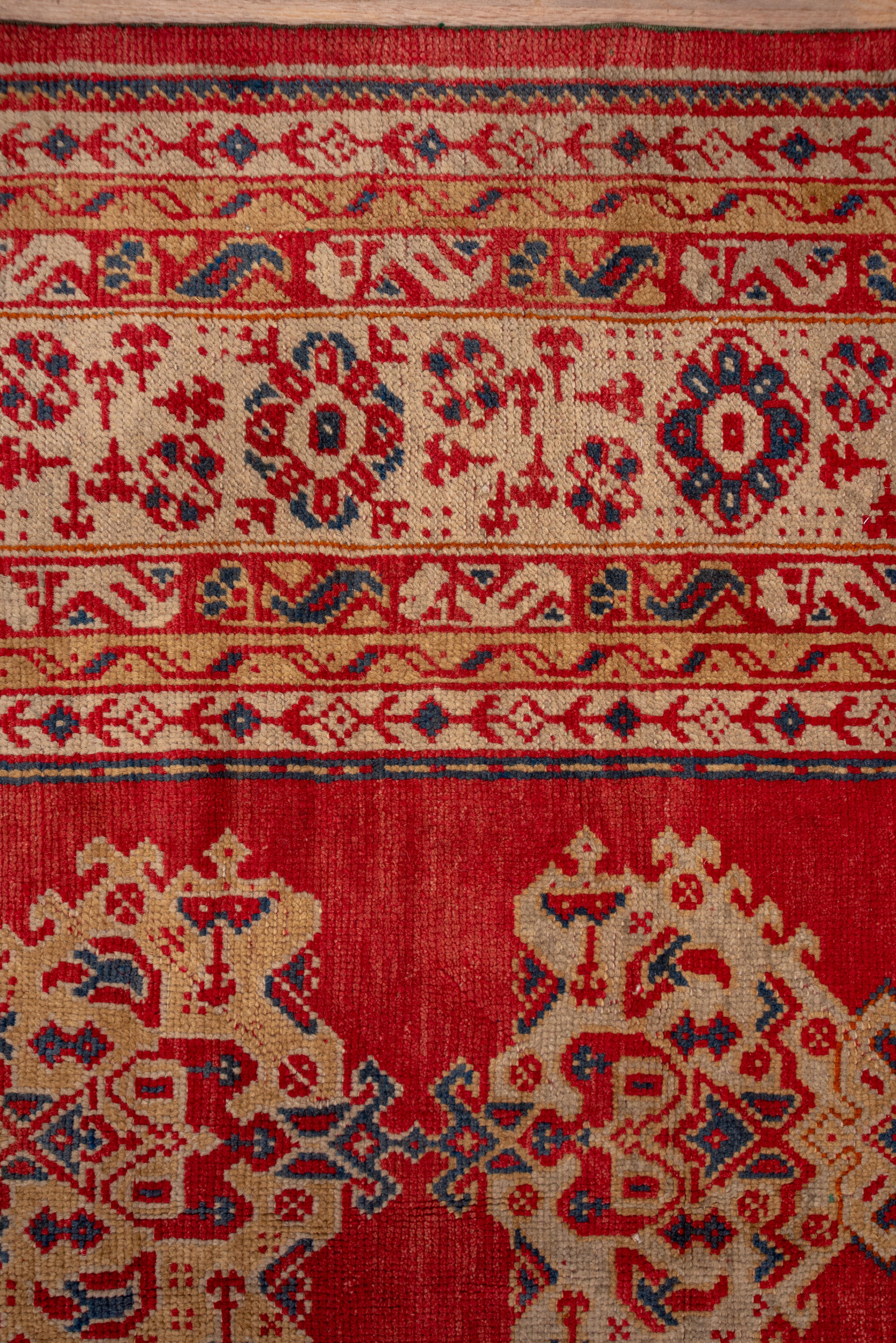 On a Turkey red field, are set five columns of hooked palmettes alternate with Yaprak (Leaf) verticals in a pattern derived from 18th century Smyrna Oushak carpets. The light green border displays octagon rosettes and bent hyacinth sprays. The