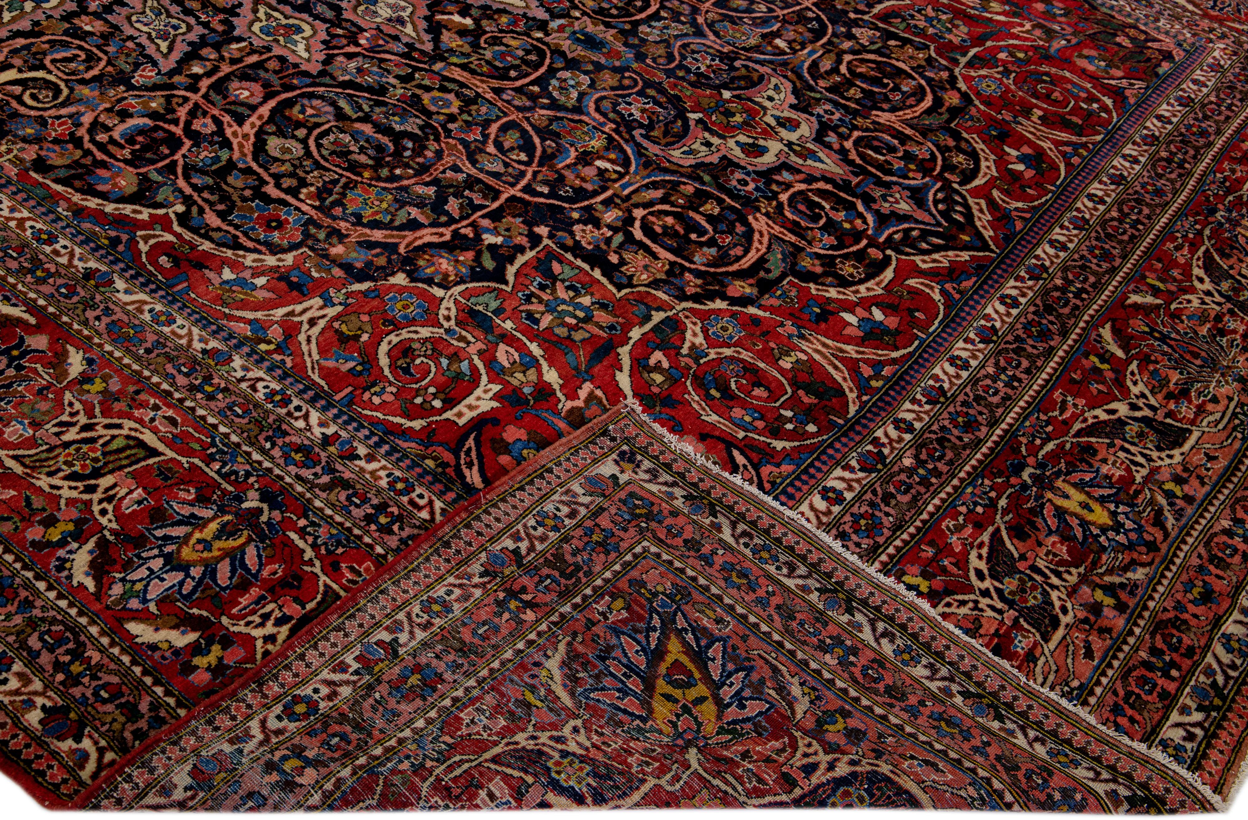 Beautiful Antique Bakhtiari hand-knotted wool rug with a red field. This Persian piece has all-over bright accent colors in a gorgeous r classic rosette design.

This rug measures 11'9
