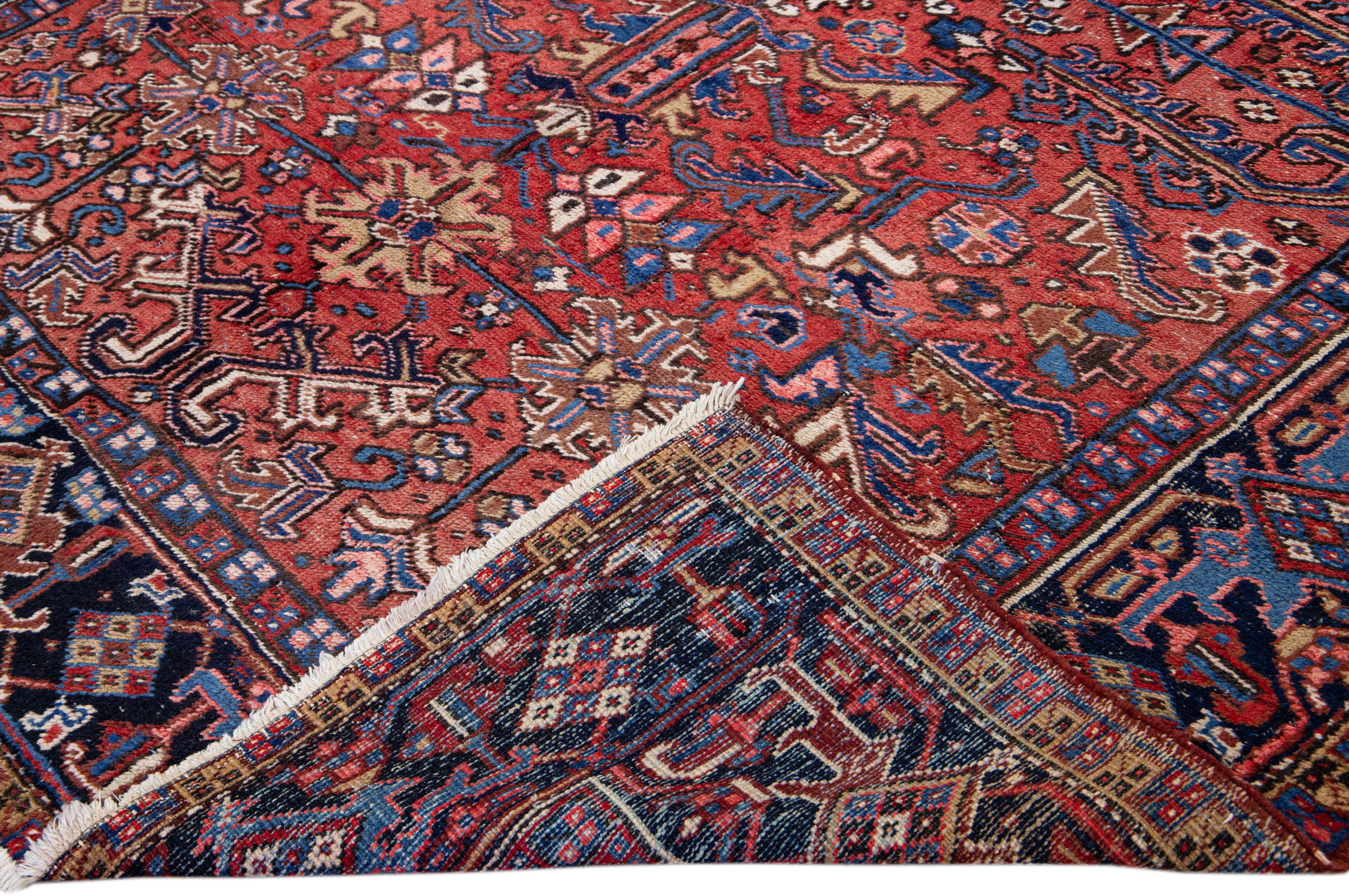 Beautiful antique Heriz Serapi hand-knotted wool rug with a red field. This Heriz rug has a navy-blue designed frame and multi-color accents in a gorgeous all-over Medallion floral design.

This rug measures: 7'7