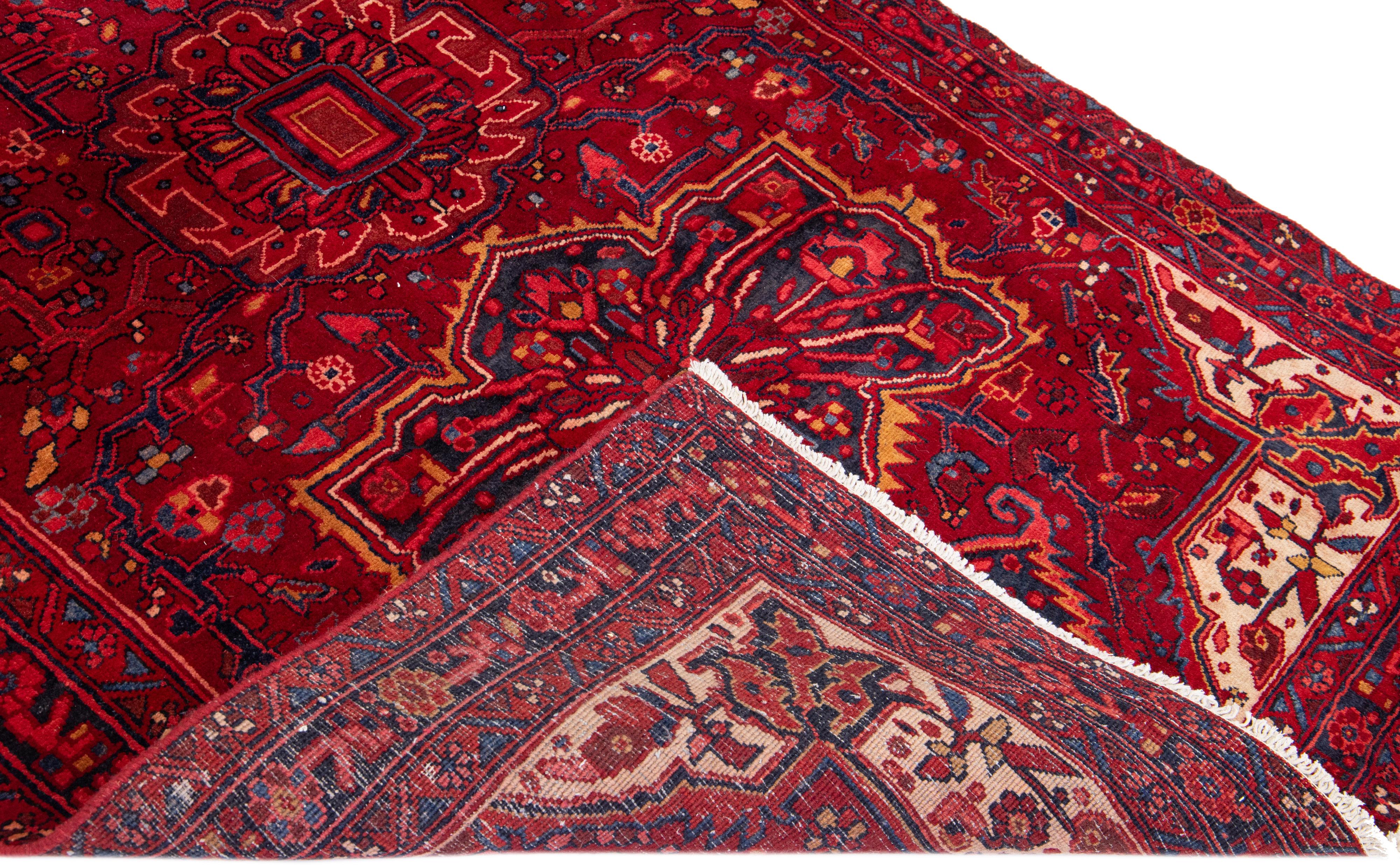Beautiful antique Heriz hand-knotted wool rug with a red field. This Heriz rug has a navy blue frame and multi-color accents in a gorgeous all-over medallion floral design.

This rug measures: 5'1