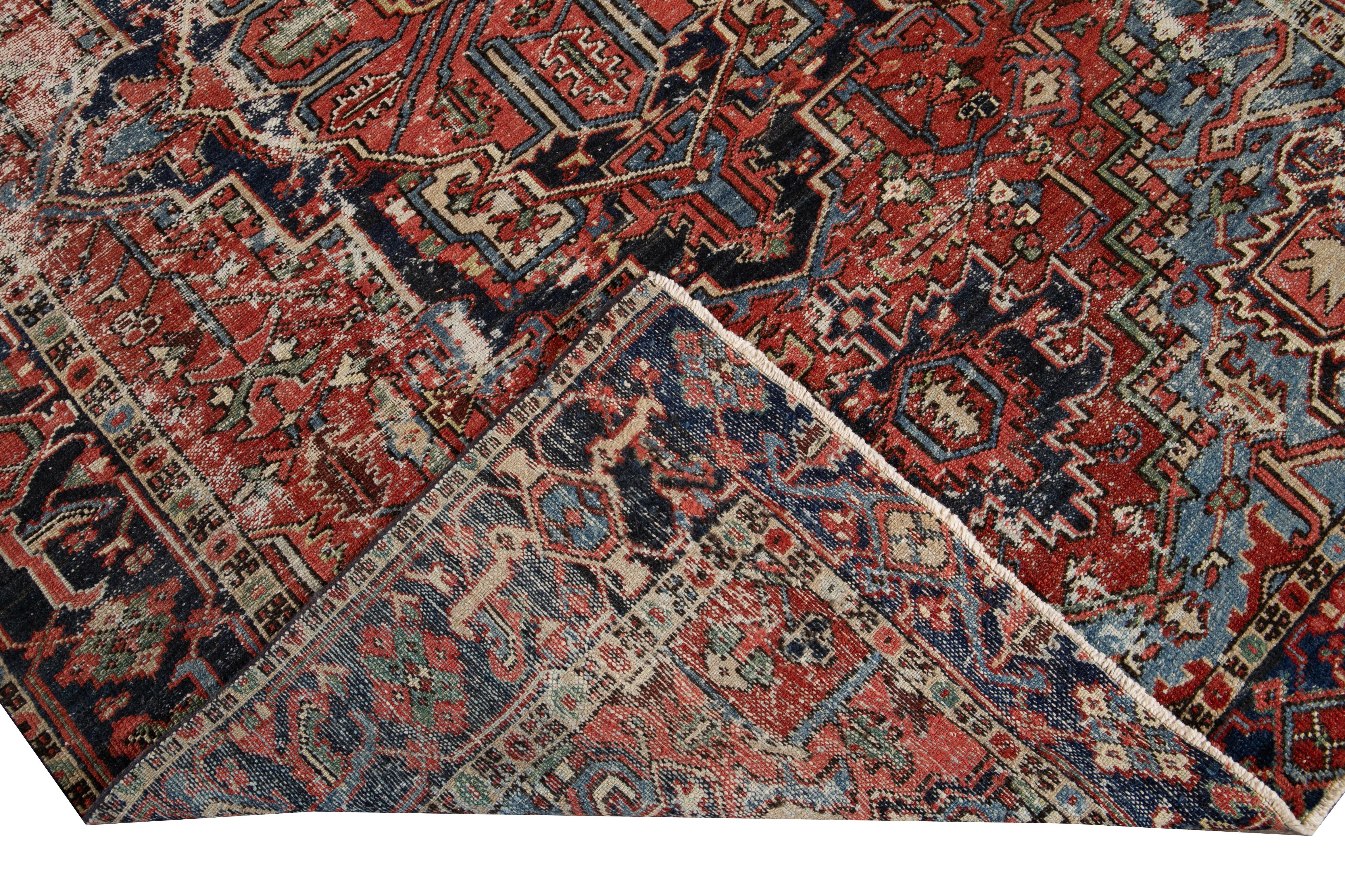 Beautiful antique Heriz hand-knotted wool rug with a red field. This Heriz rug has a dark blue frame and multi-color accents in a gorgeous all-over geometric medallion floral design.

This rug measures: 5'11