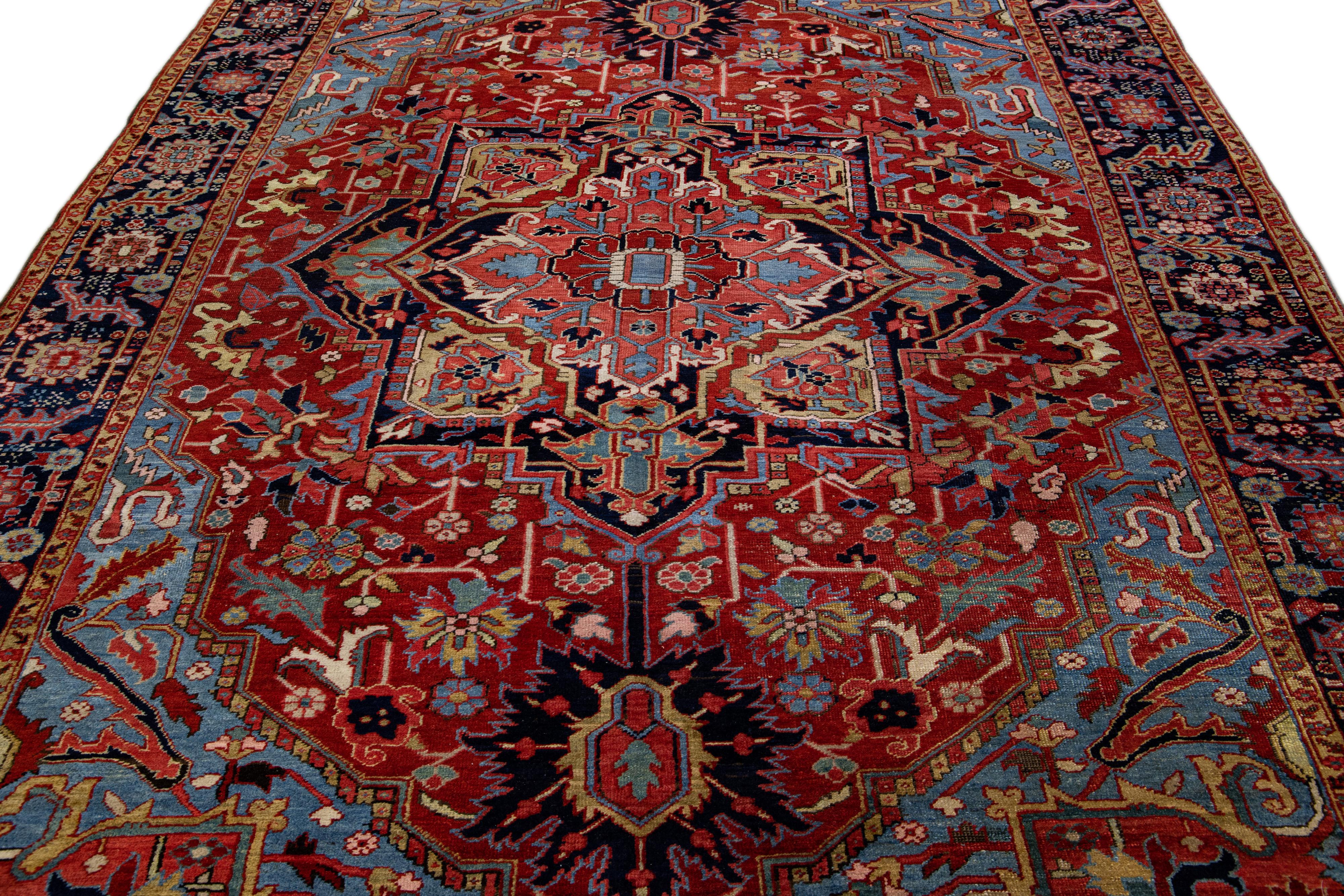 Beautiful antique Heriz hand-knotted wool rug with a red field. This Heriz rug has a navy-blue frame and multi-color accents in a gorgeous all-over Medallion floral design.

This rug measures: 7'8