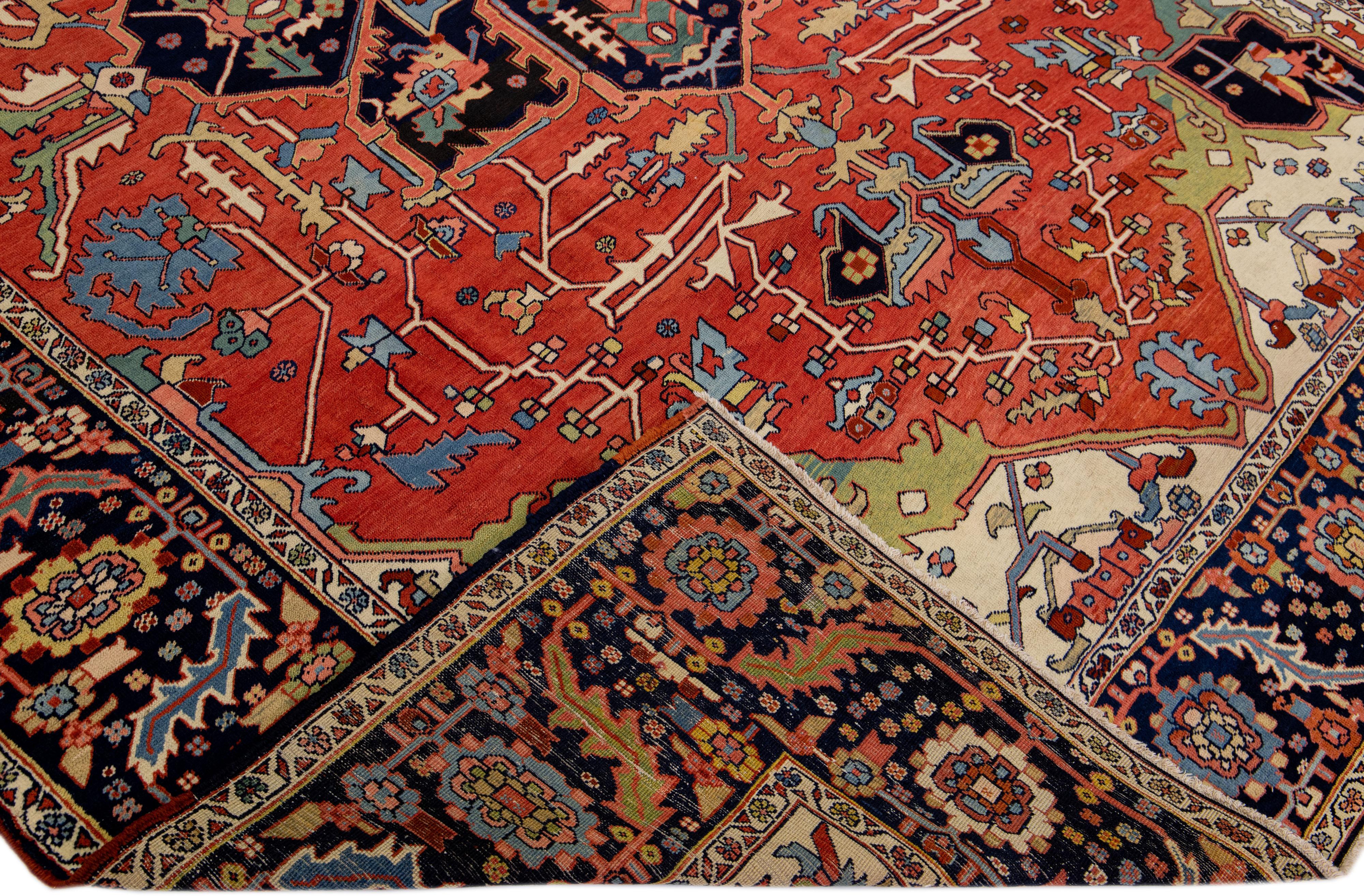 Magnifique tapis ancien Heriz Serapi du 19ème siècle en laine nouée à la main avec un champ rouge. Ce tapis persan a un cadre bleu foncé avec des accents multicolores qui présentent un magnifique motif de médaillon sur toute la surface.

Ce tapis