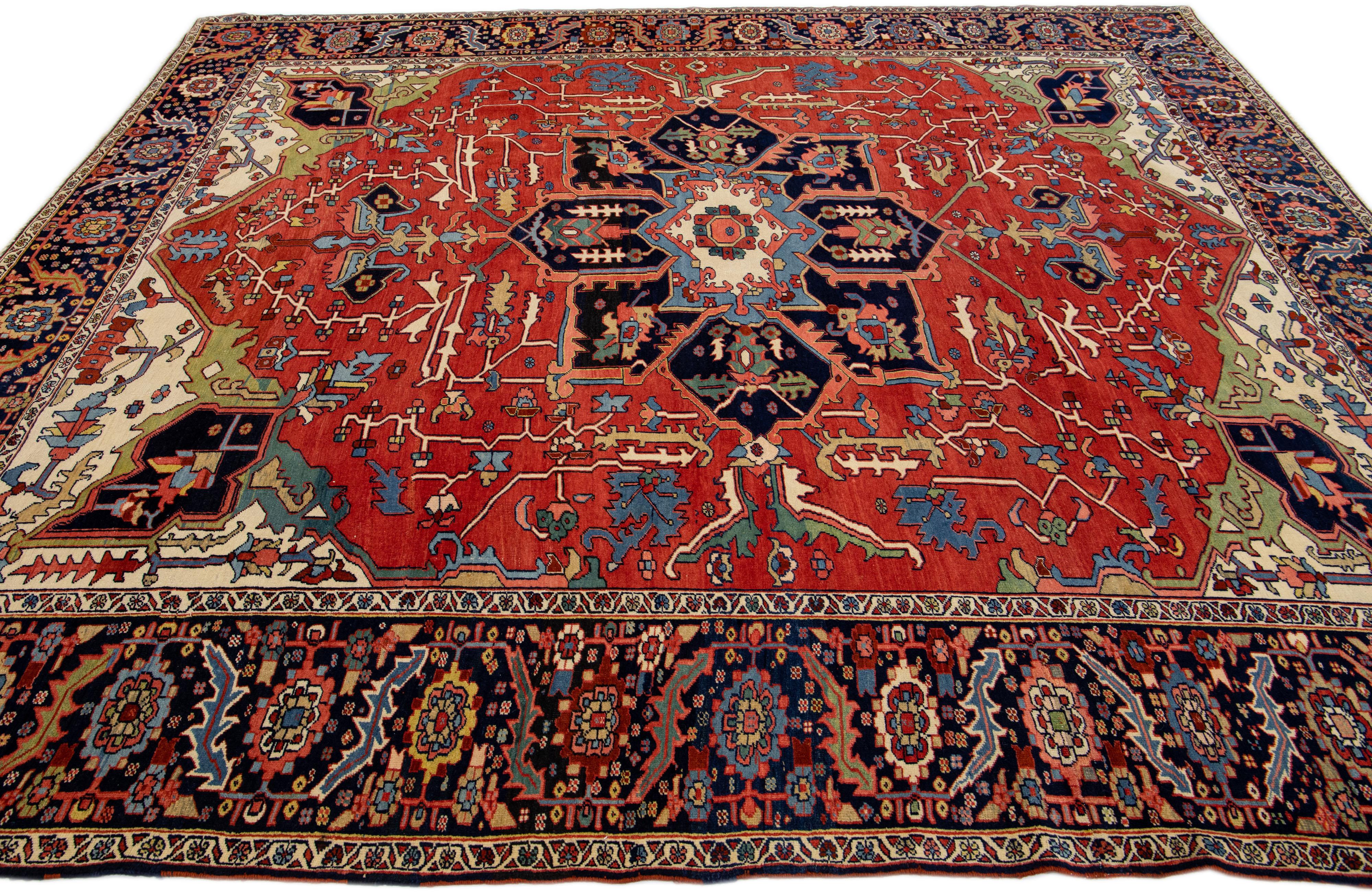 Noué à la main Tapis persan ancien Serapi rouge en laine fait à la main avec motif de médaillon multicolore en vente