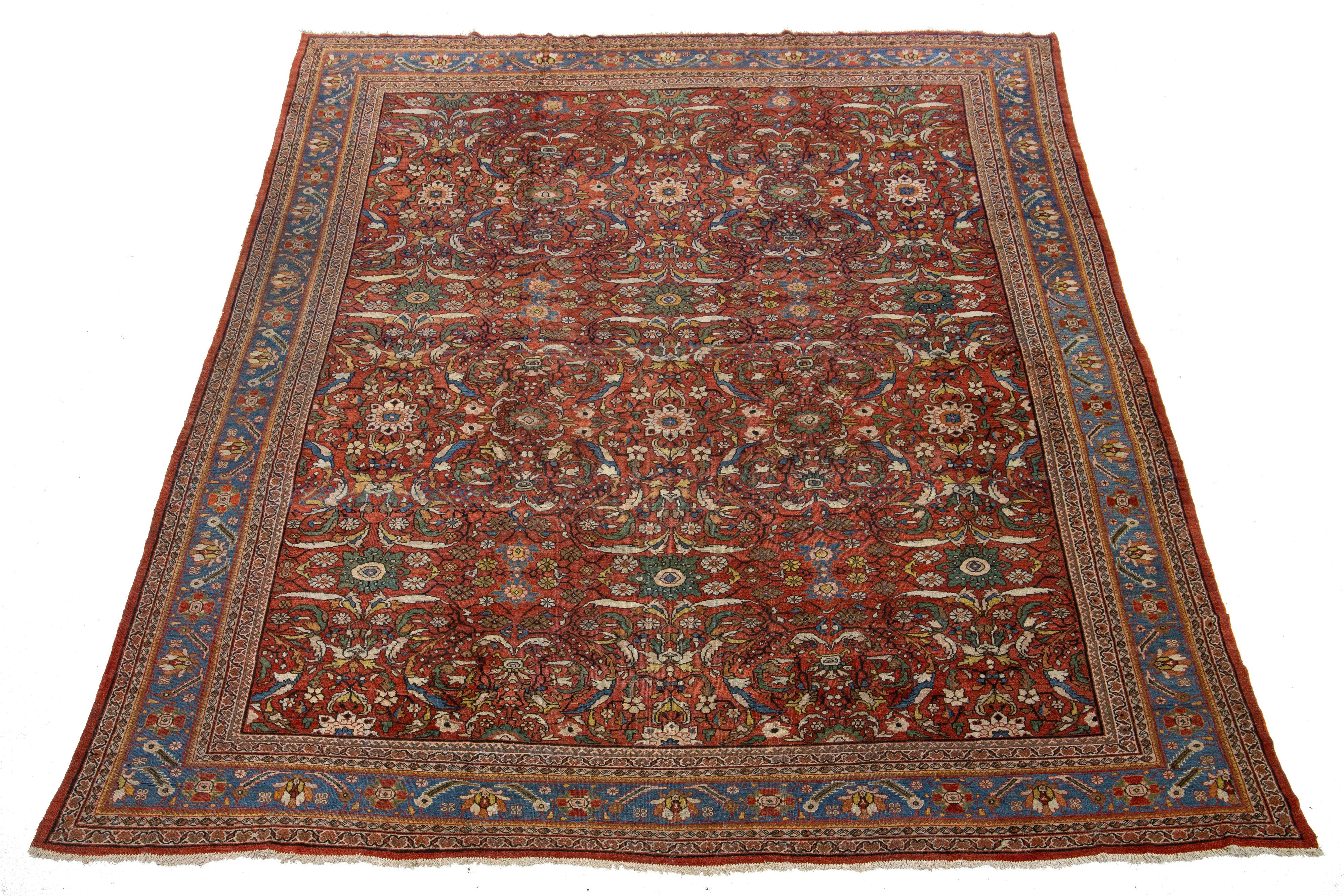 Découvrez l'élégance intemporelle d'un tapis surdimensionné Sultanabad antique en laine nouée à la main. Ce tapis présente un captivant design/One orné d'accents multicolores vibrants sur un luxueux fond rouge.

Ce tapis mesure 13' x 17'1