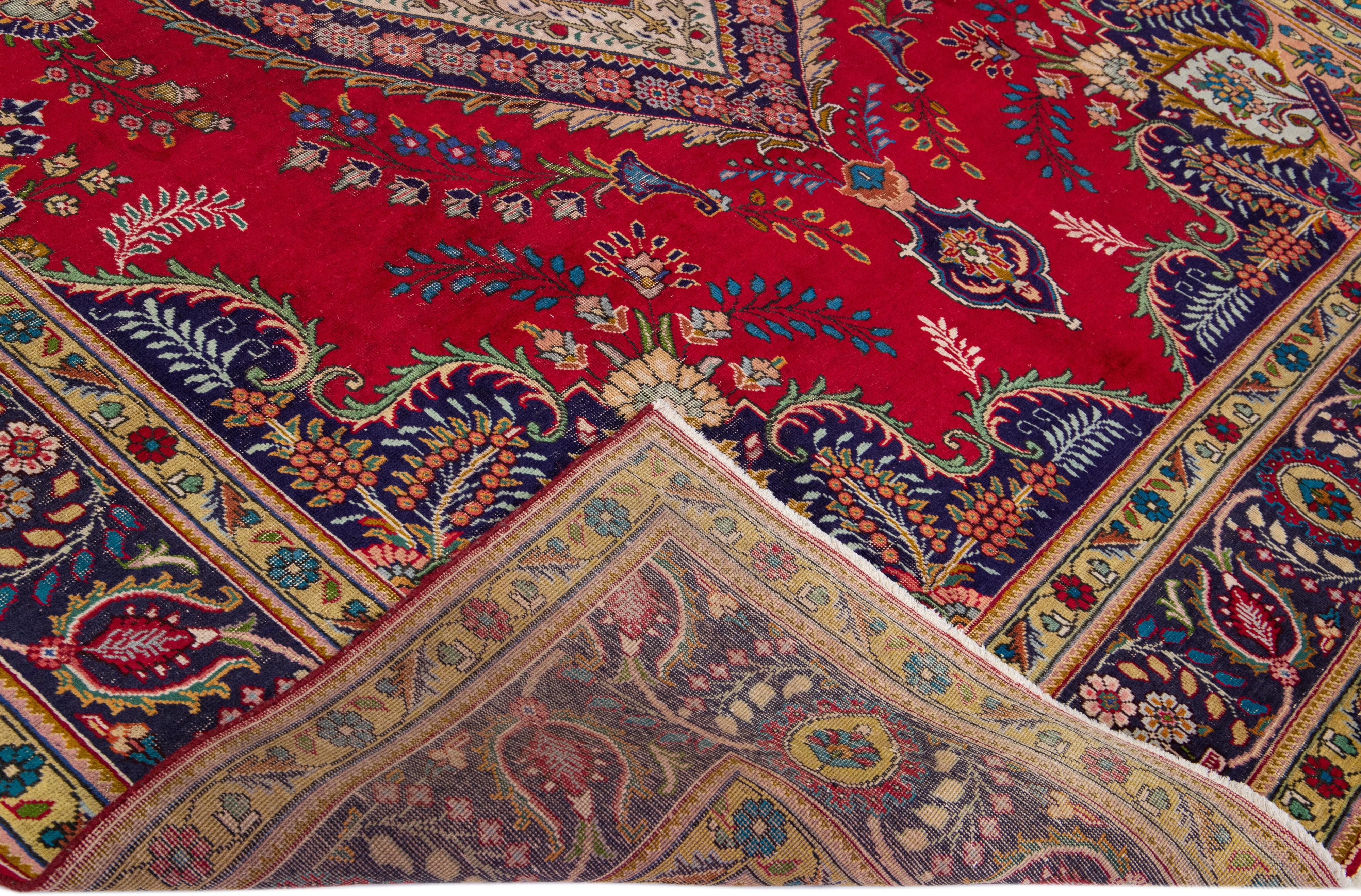 Beautiful antique Tabriz hand-knotted wool rug with a red field. This Persian piece has a blue frame and multicolor accents in a gorgeous all-over Shab Abbasi design. 

This rug measures: 9'11