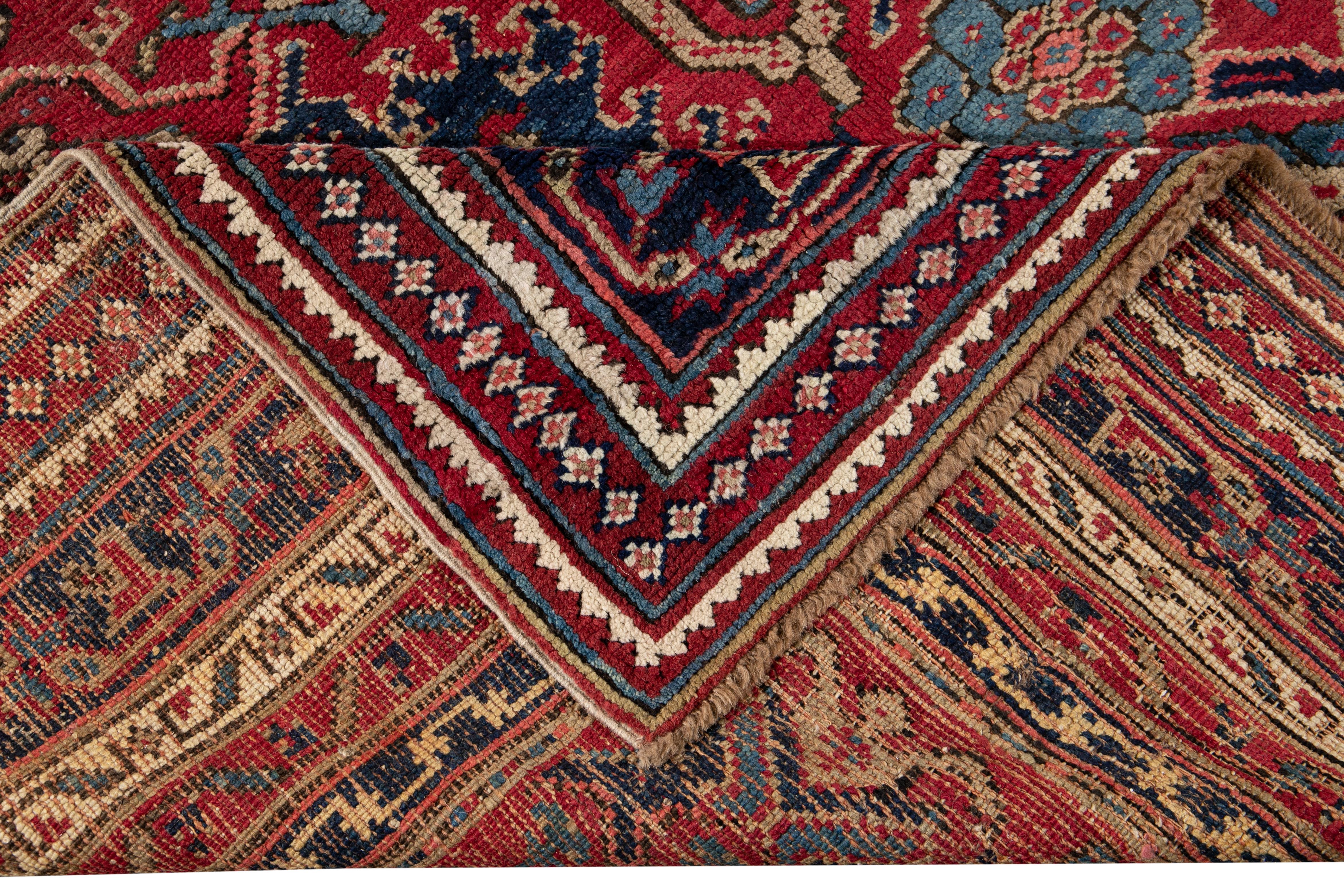 Beautiful Antique Turkish hand-knotted wool rug with a red field. This rug has a designed blue frame with multicolor accents in a gorgeous large-scale floral pattern.

This rug measures: 11'6