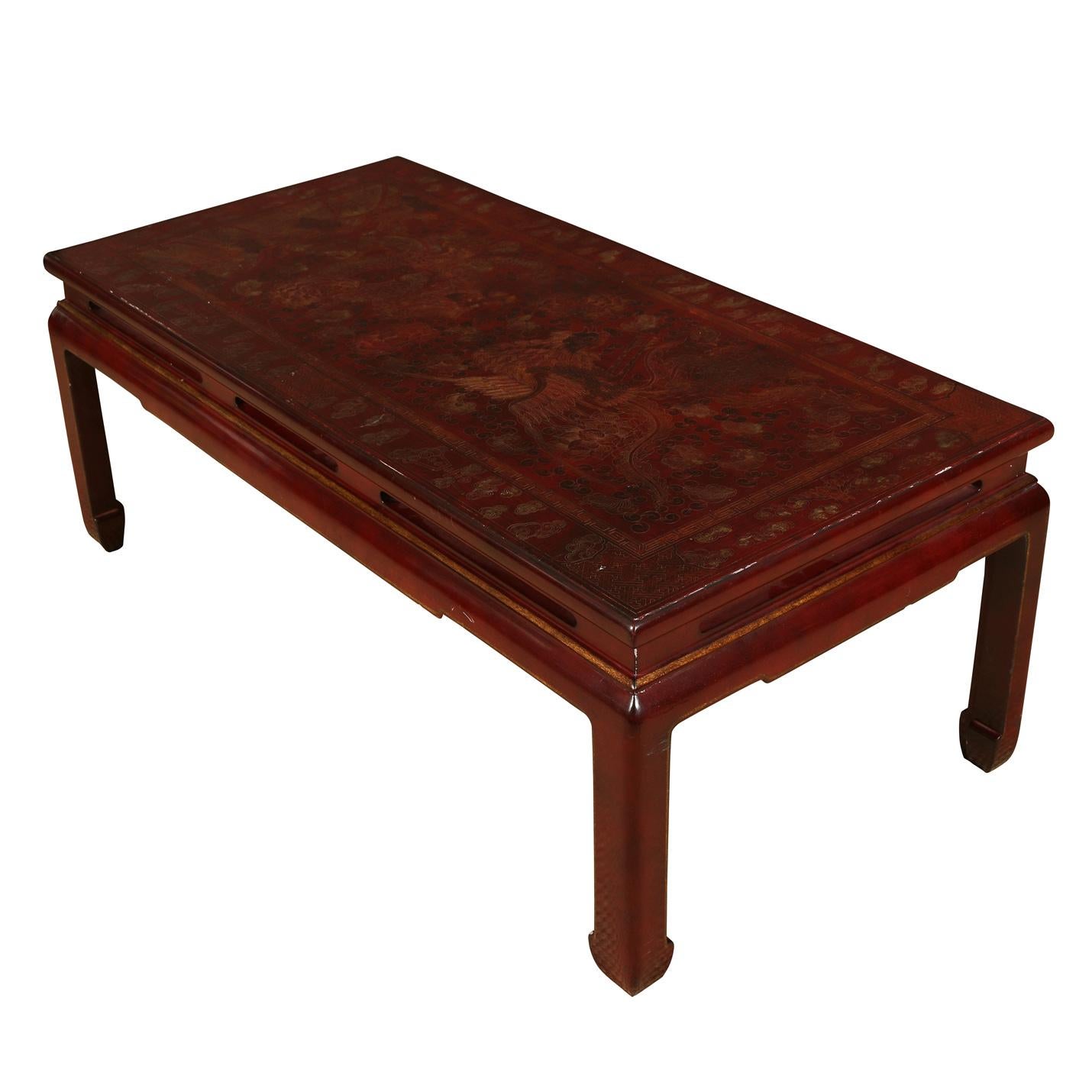 Asian red lacquer coffee table with chinoiserie etched detail with a dragon and phoenix motif.