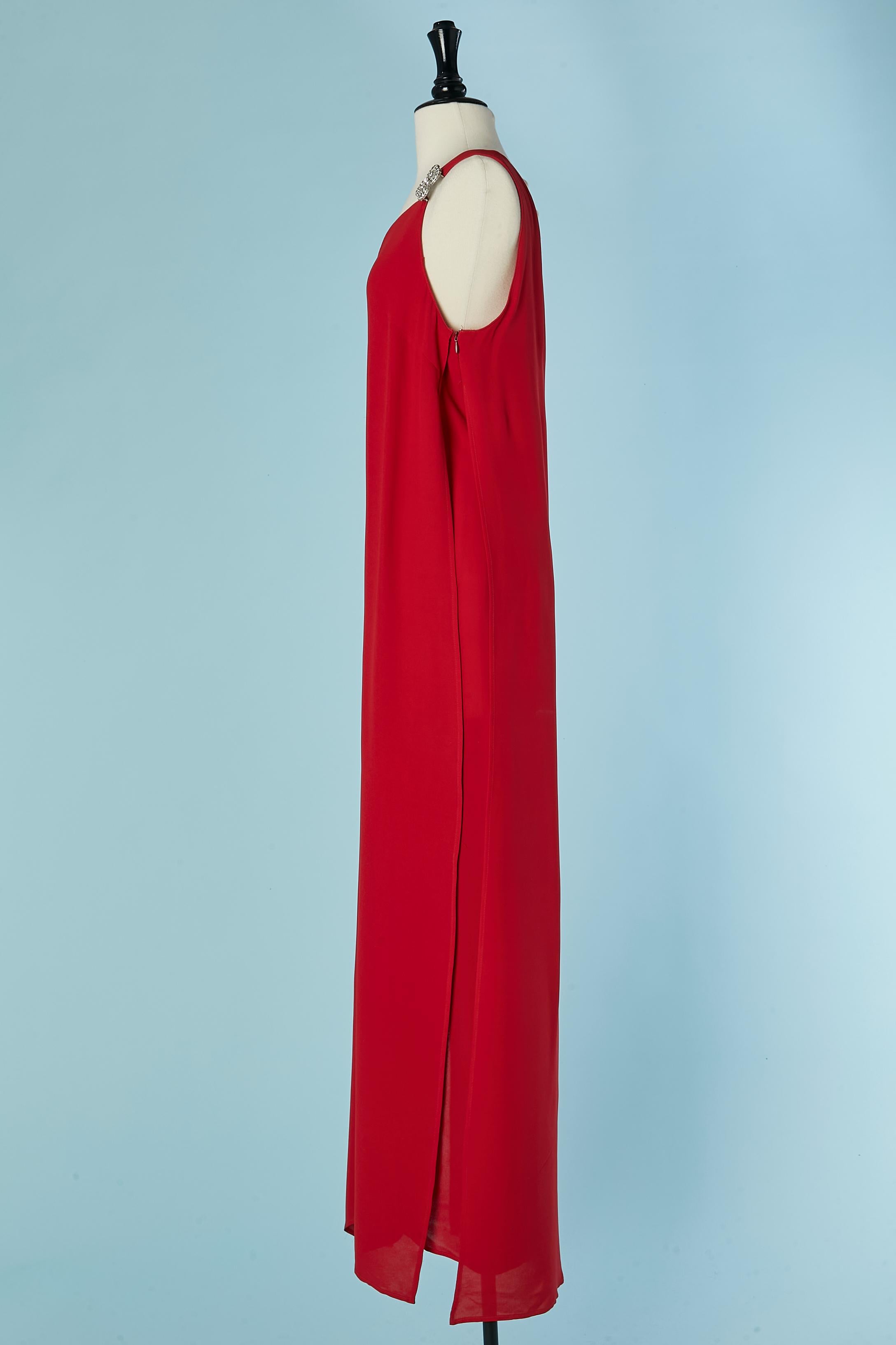 Rotes asymmetrisches Abendkleid mit Strassbroschenverzierung auf der linken Schulter, das Kleid besteht aus 2 Lagen, wobei die obere Lage auf beiden Seiten geteilt ist. Zusammensetzung des Hauptgewebes: Seide
Reißverschluss und Haken-Ösen-Verschluss
