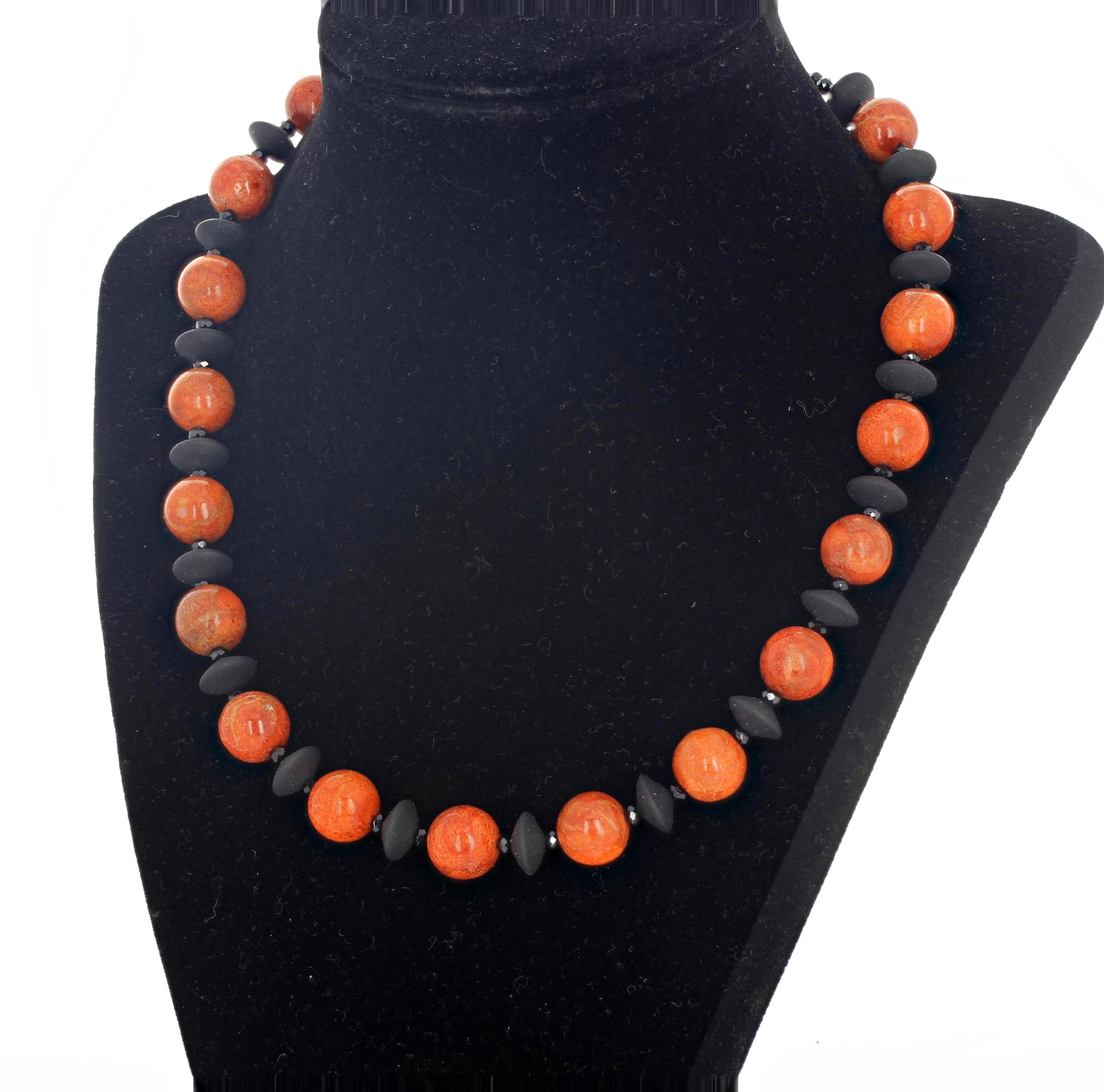 Rare round reddish orangy natural Bamboo Coral (11 mm) set with designer disks of beautiful polished flat black Onyx and brilliant gem cut sparkling little black Spinels in a necklace 18 inches long with a gold tone clasp. 