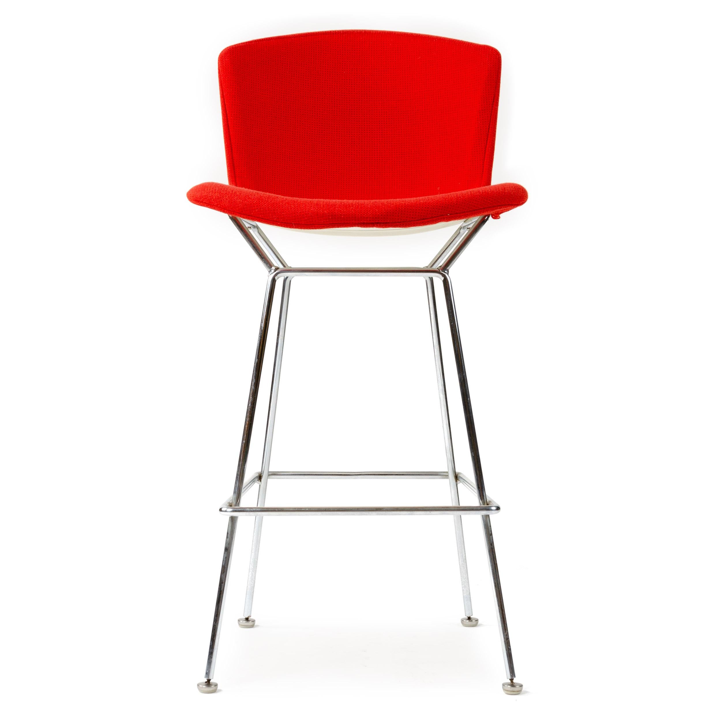 A spare and sculptural stool crafted from shaped steel rods, retaining the original red upholstery. Measures: 40.5