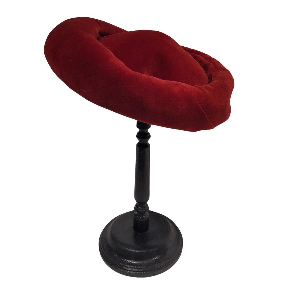 Encantador sombrero de estilo Art Nouveau, fabricado en Francia a principios del siglo XX. Tiene una silueta redondeada y abombada, con un borde grueso y curvado. El tejido, de terciopelo rojo, completa el encanto de la pieza. Por un lado, su
