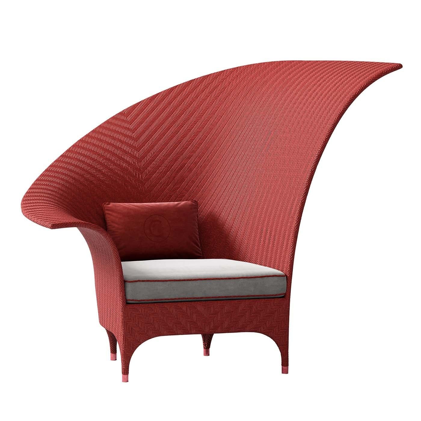A true work of art, whose singularity lies in the balance of its proportions, this superb armchair's architectural silhouette evokes the sail of a boat. A statement piece on a terrace, patio, or poolside, the red resin-covered aluminum frame has