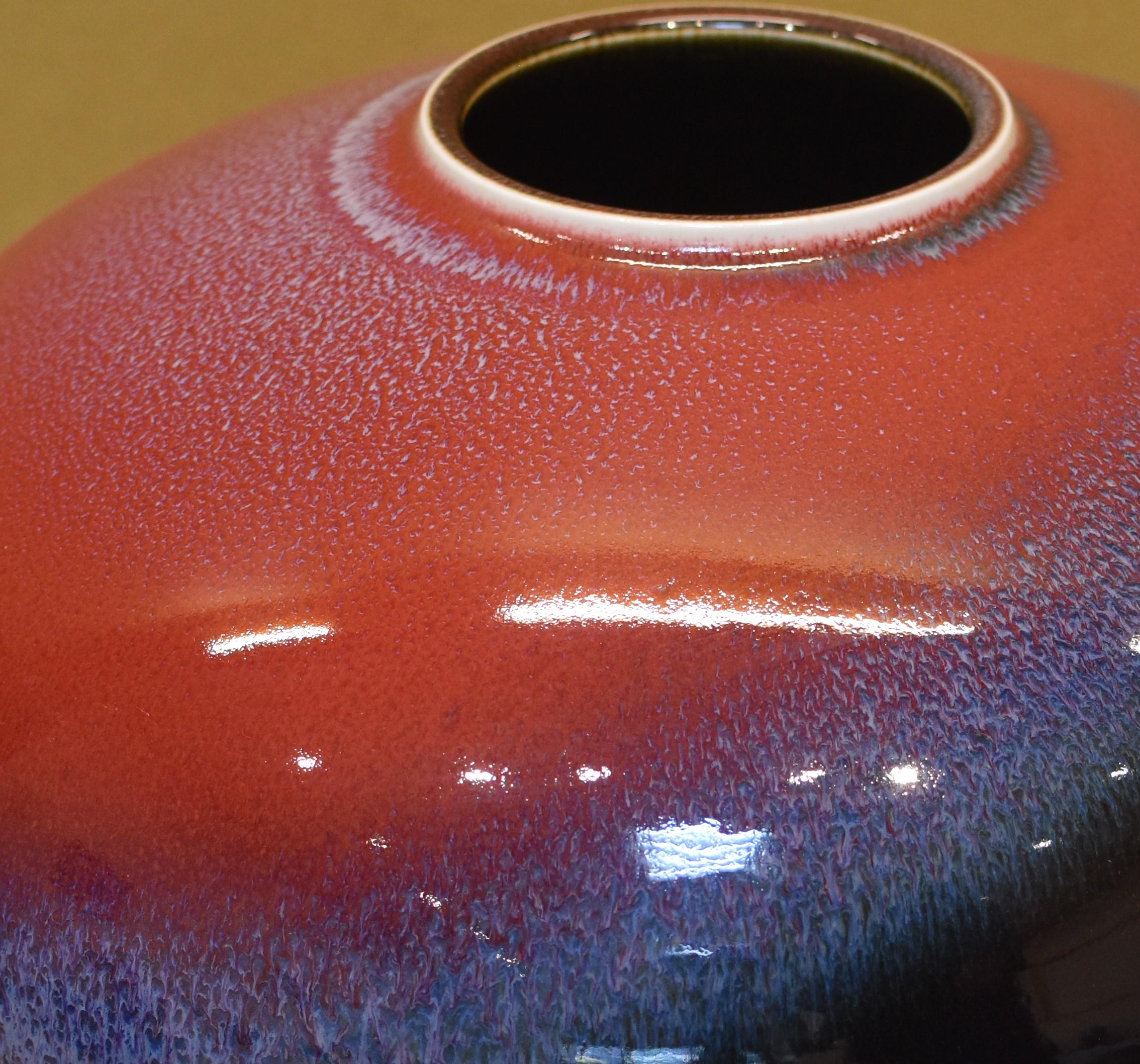 Faszinierende zeitgenössische dekorative japanische Porzellanvase von außergewöhnlichem Charme, ein Ausstellungsstück, das in lebhaftem Blau, Rot und Schwarz auf einem wunderschön geformten Körper von Hand glasiert ist. Die für den Künstler