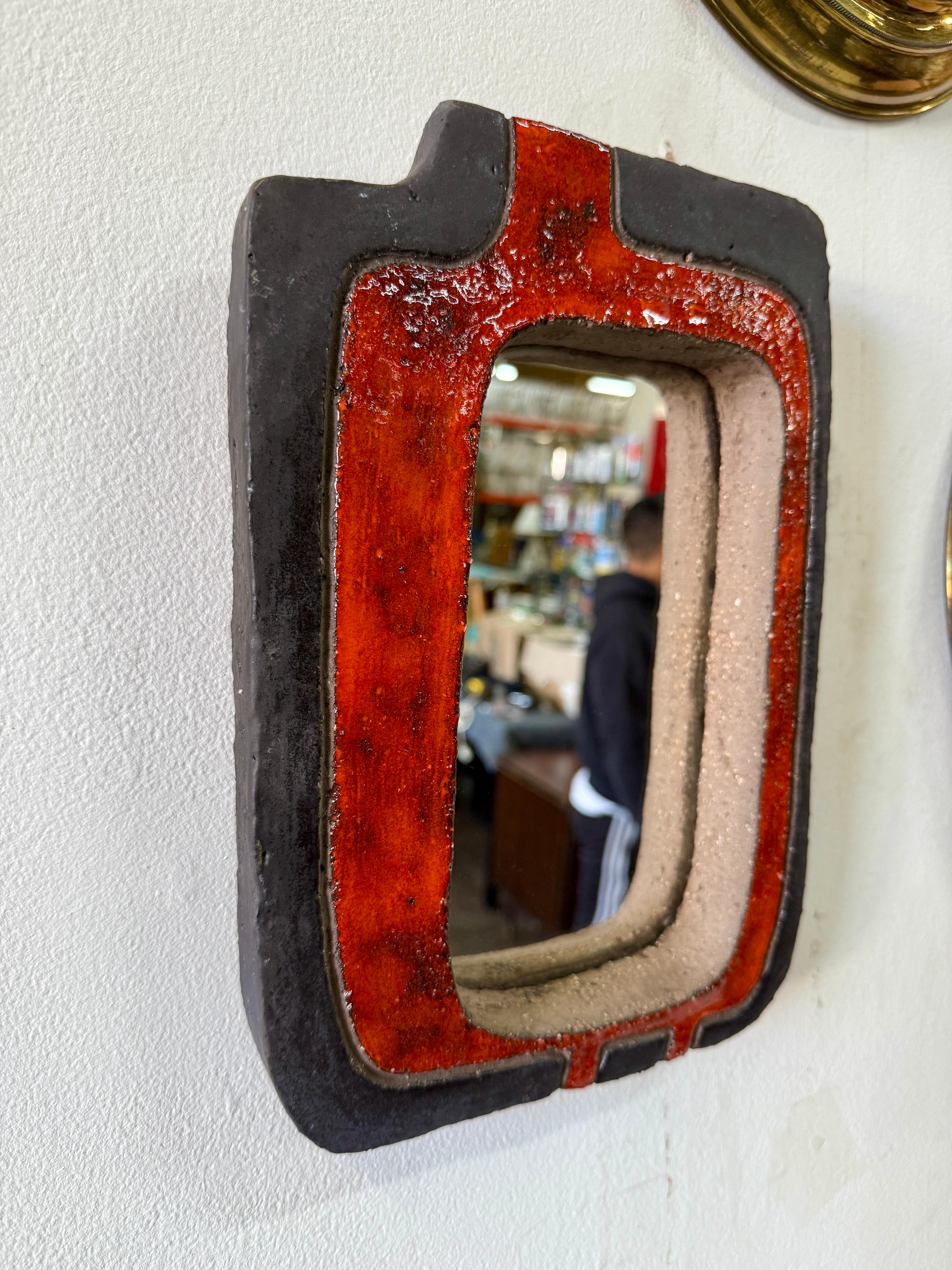 Nathalie Soufflet, artiste contemporaine ancrée dans l'enclave artistique de Vallauris, puise profondément dans les influences amérindiennes. Ce miroir en céramique, avec sa forme abstraite, fait une déclaration frappante dans une glaçure vive. Le