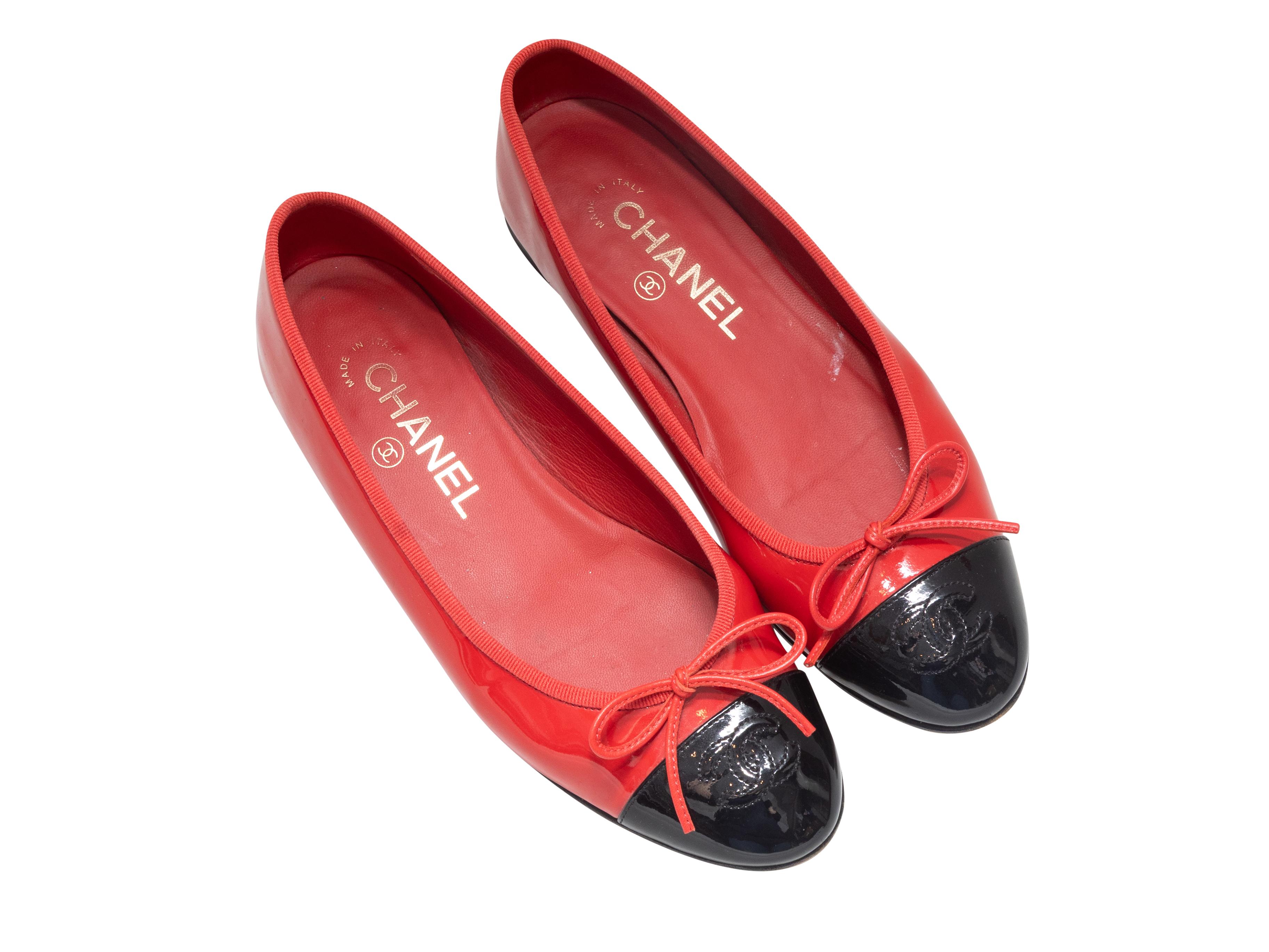 Ballerines à capuchon en vernis rouge et noir de Chanel. Garniture en gros-grain et nœud sur le dessus. Hauteur du talon : 0,5