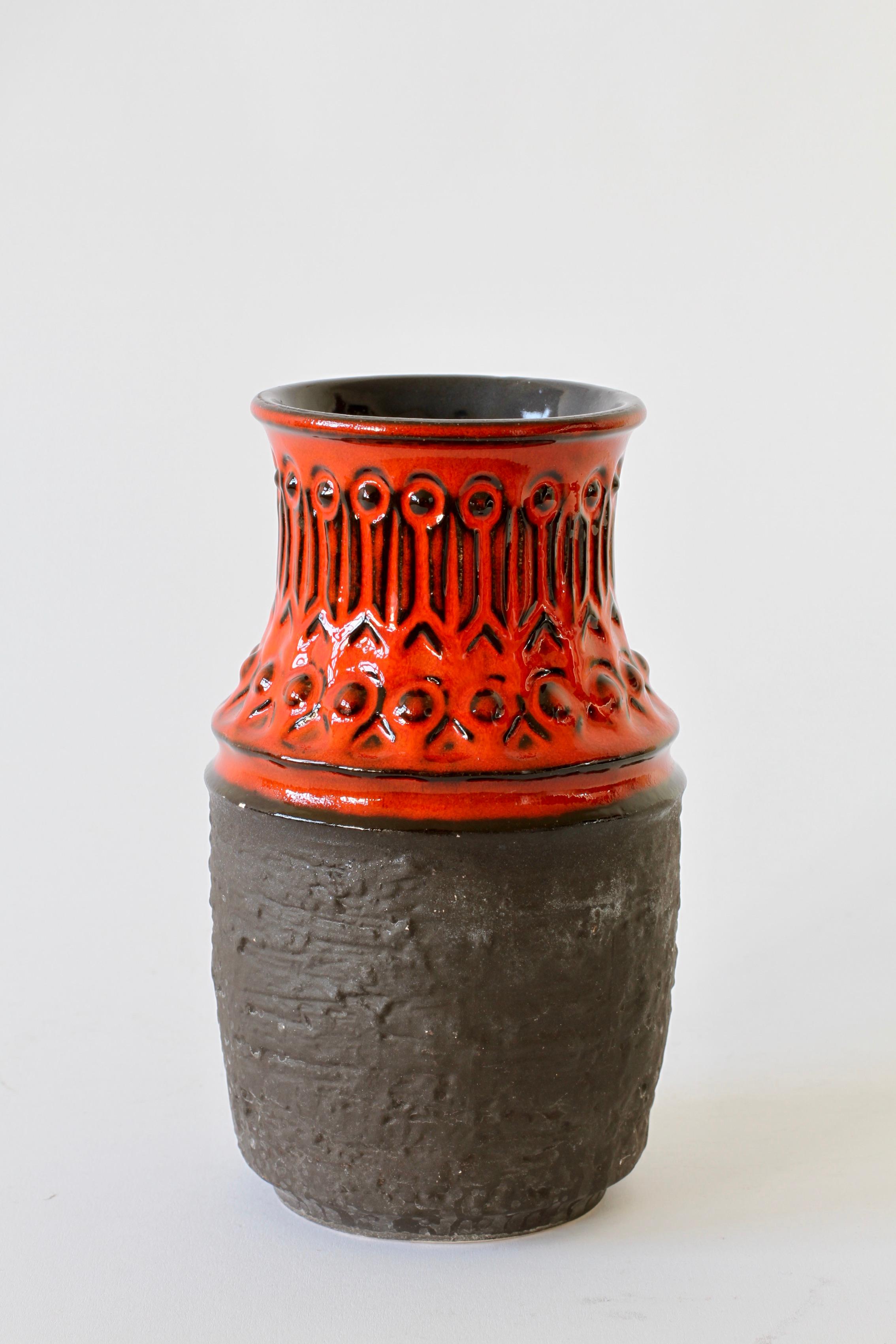Eine schöne Vase in auffälligem Rot und Mattschwarz mit Prägemuster - Formnummer 1 582 20 - hergestellt von Jasba Pottery Mitte der 1970er Jahre.

Auf dunklen Palisander- und Teakholztischen oder -regalen, die von dänischen Designern wie Hans