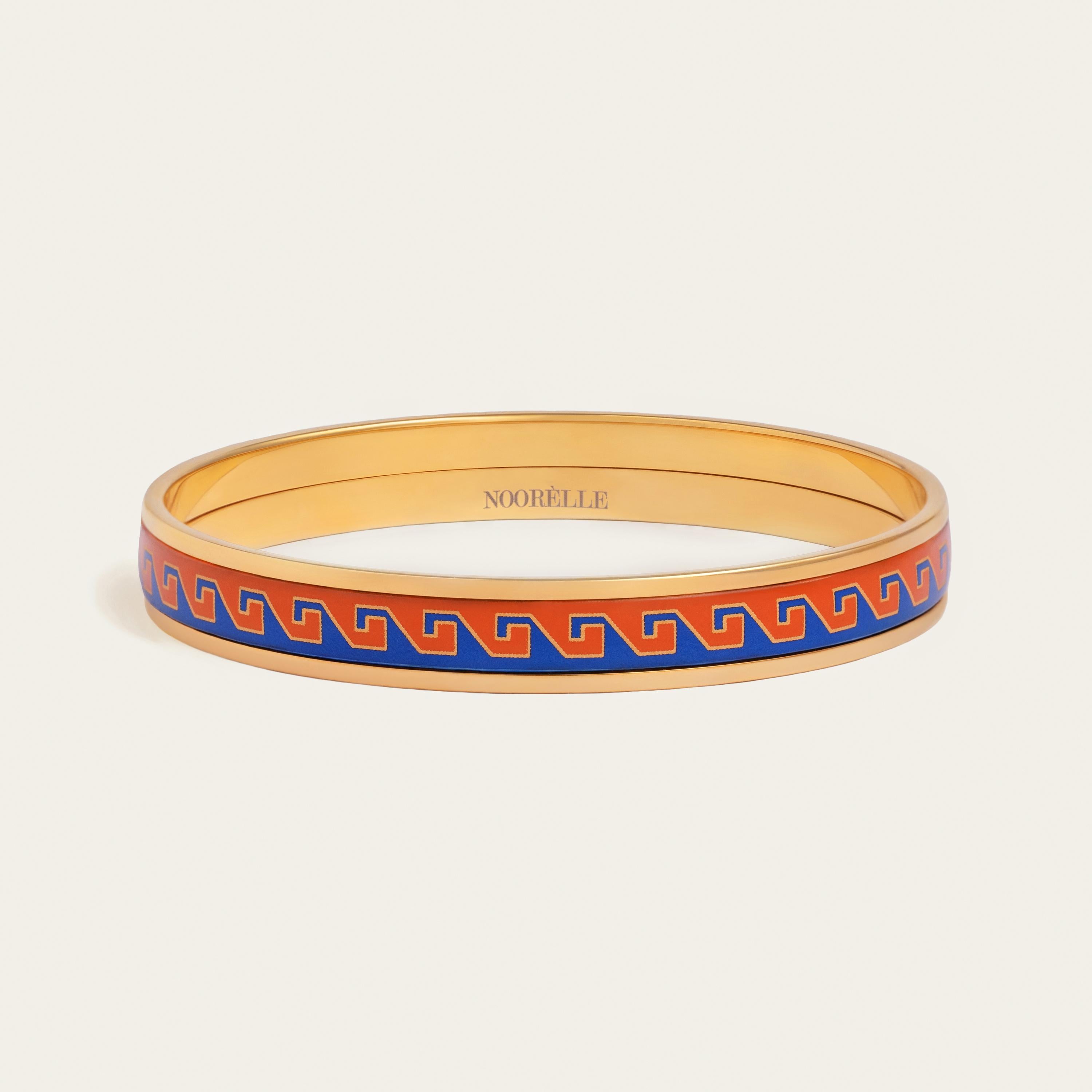 Elevate your style with our exquisite 18k gold-plated stainless steel bangle. Hand-painted with genuine fire enamel in vivid colors that will last forever, this luxurious piece is designed to make a statement. Hypoallergenic and made to last, wear