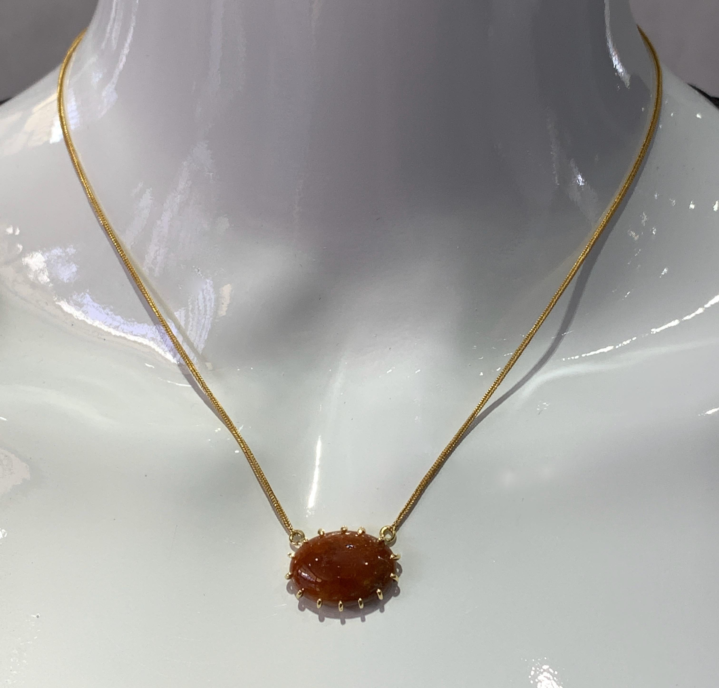 This sexy, slinky one-of-a-kind little pendant, handmade here in our shop by Eytan Brandes, features a smooth 18x13 cabochon of nicely mottled reddish-brown jadeite.  Instead of a bezel, the stone is held in place by fourteen prominent teeth -- a