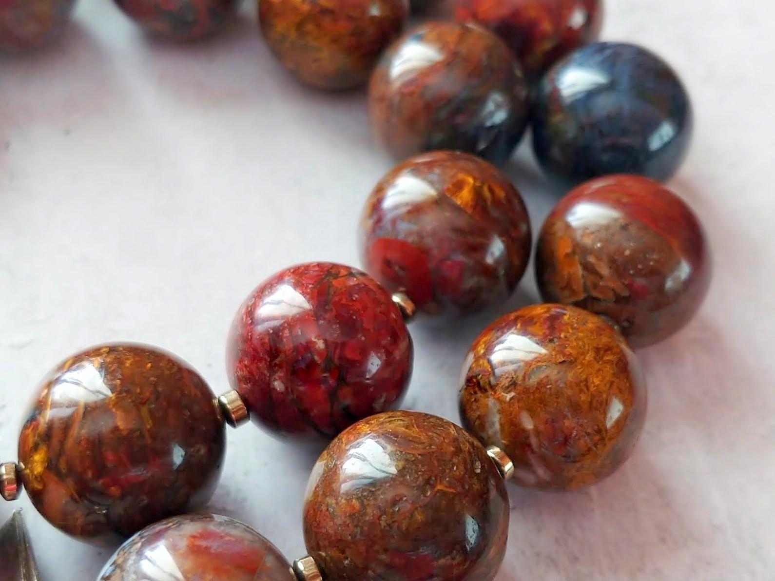 The necklace is 18.5 inches (47 cm) long. The rare size of the smooth round beads is 17.5 mm.
The beads are rare, of excellent quality, and unique color. Ranging in color from brownish-red, to blue-grey, and chatoyant yellow. The beads seem to glow