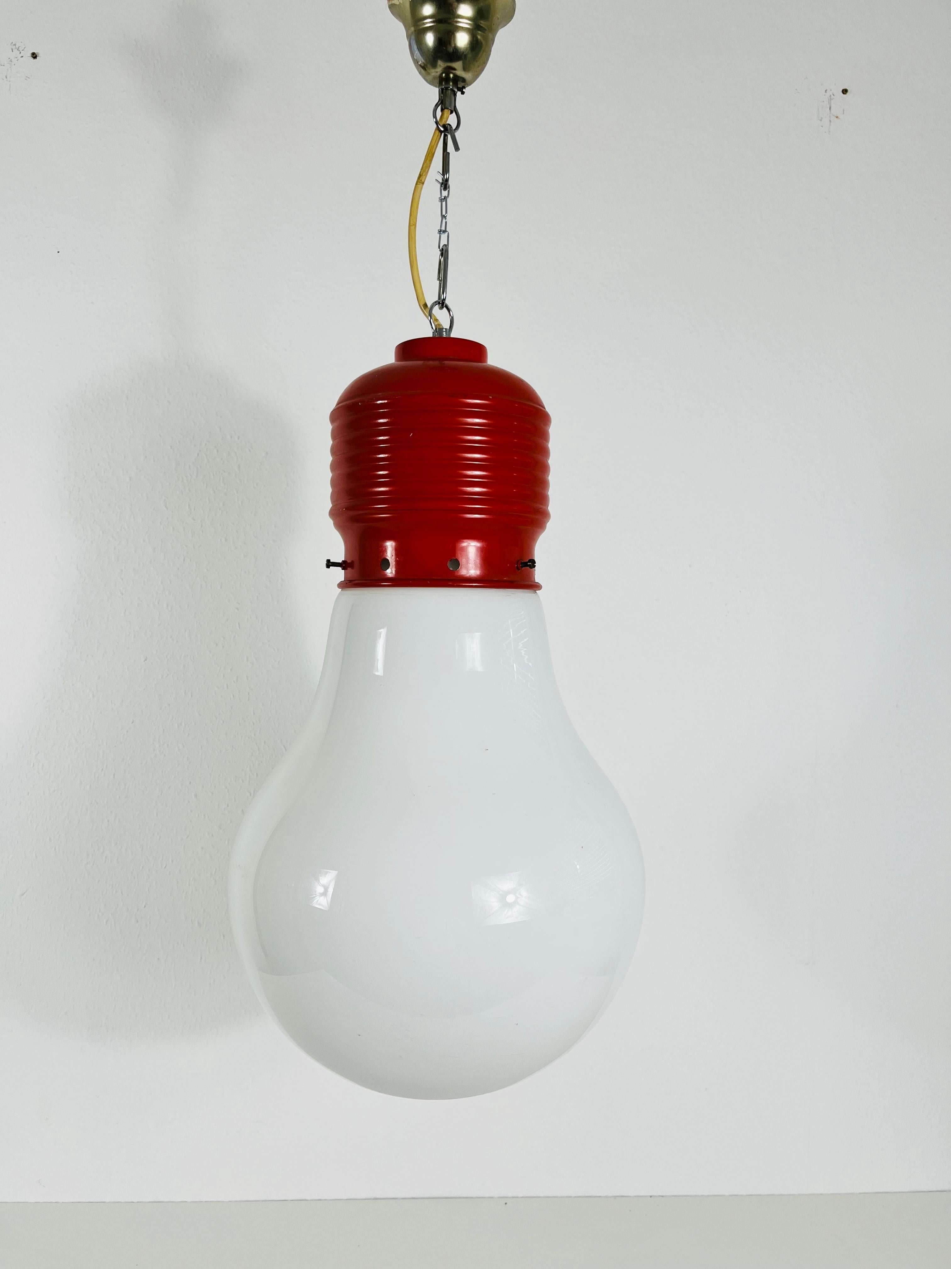 Seltene rote Pendelleuchte, entworfen von dem deutschen Designer Ingo Maurer in den 1960er Jahren. Die Leuchte hat eine einzigartige Glühbirnenform, die charakteristisch für Ingo Maurer ist.

Die Leuchte benötigt eine E27-Glühbirne. Funktioniert
