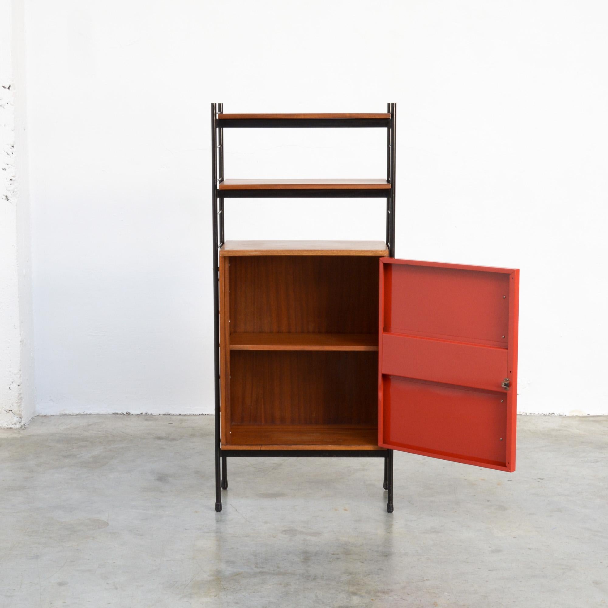 This rare cabinet was designed by Willy Van Der Meeren for Tubax in the early 1950s.
The open black lacquered metal frame holds 2 wooden shelves and a small cabinet with a metal door. The metal door with its elegant wooden handle is red painted.