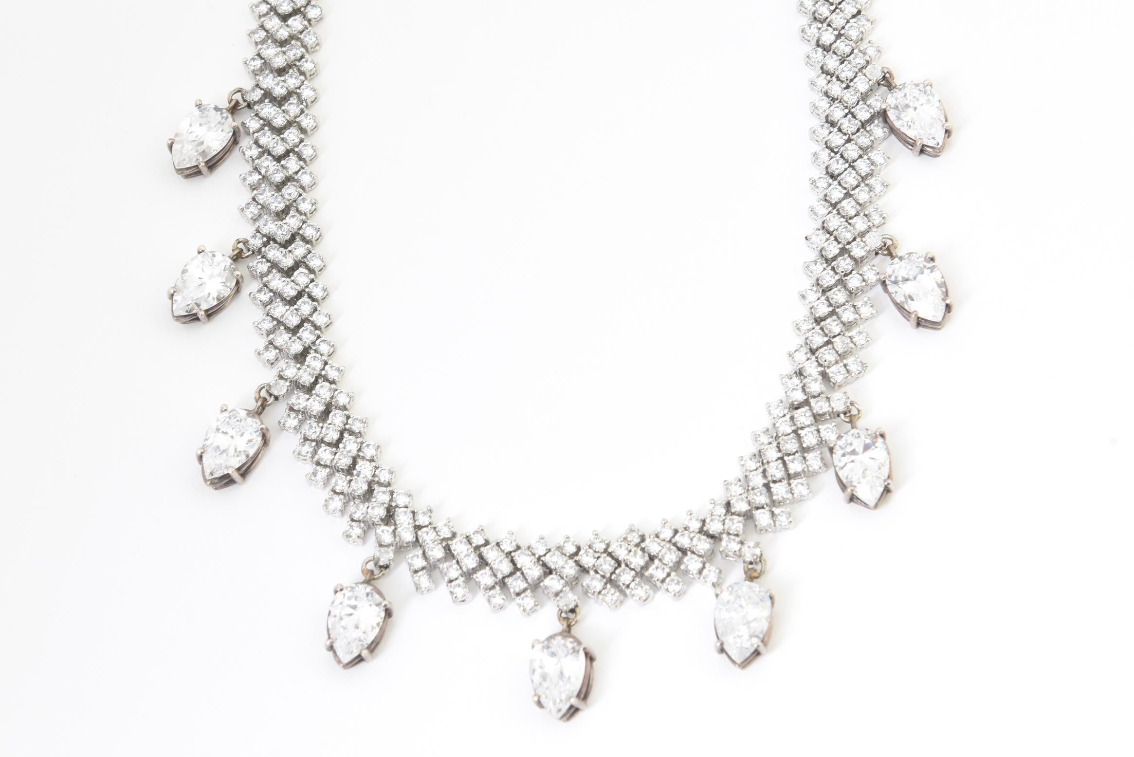 Flexible crystal necklace with nine dangling pear-shaped crystals mounted in white metal. No maker's mark. Minor wear, one pear crystal drop is cracked.
