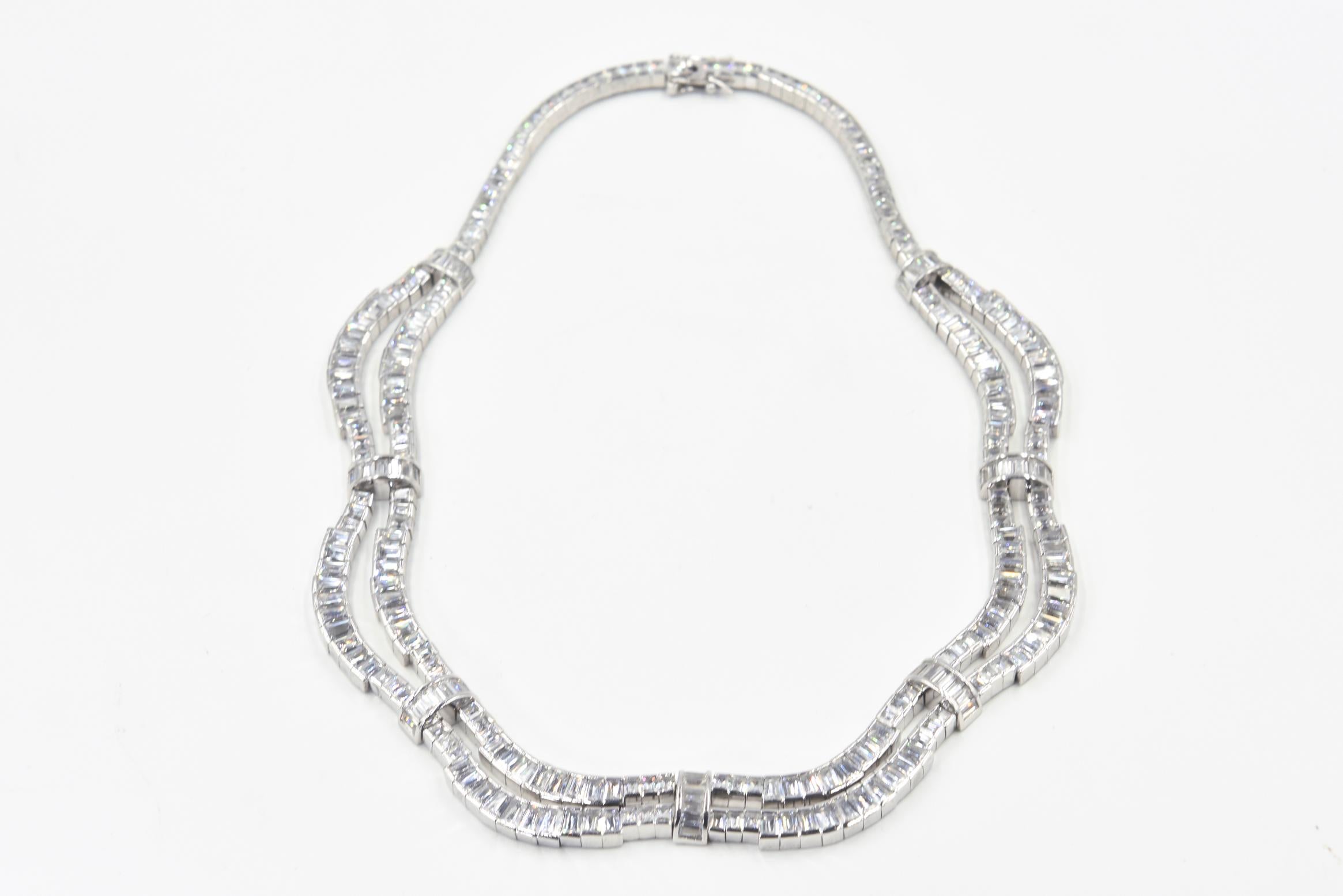 Elegant emerald cut cubic zirconia two row drop necklace with baguette CZ bridges set in rhodium sterling silver.  Perfect for a wedding, gala or big event.  Marked 925 on clasp.  It has a push button clasp with two safety clasps.  Difficult to