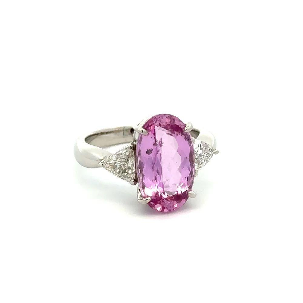 Simply Beautiful! Elegant and Finely detailed Show Stopper 3-Stone Platinum Statement Cocktail Ring. Centering a Securely nestled Hand set Long Oval Imperial Pink Topaz, weighing approx. 6.13 Carats with a Trillion Diamond on either side; weighing