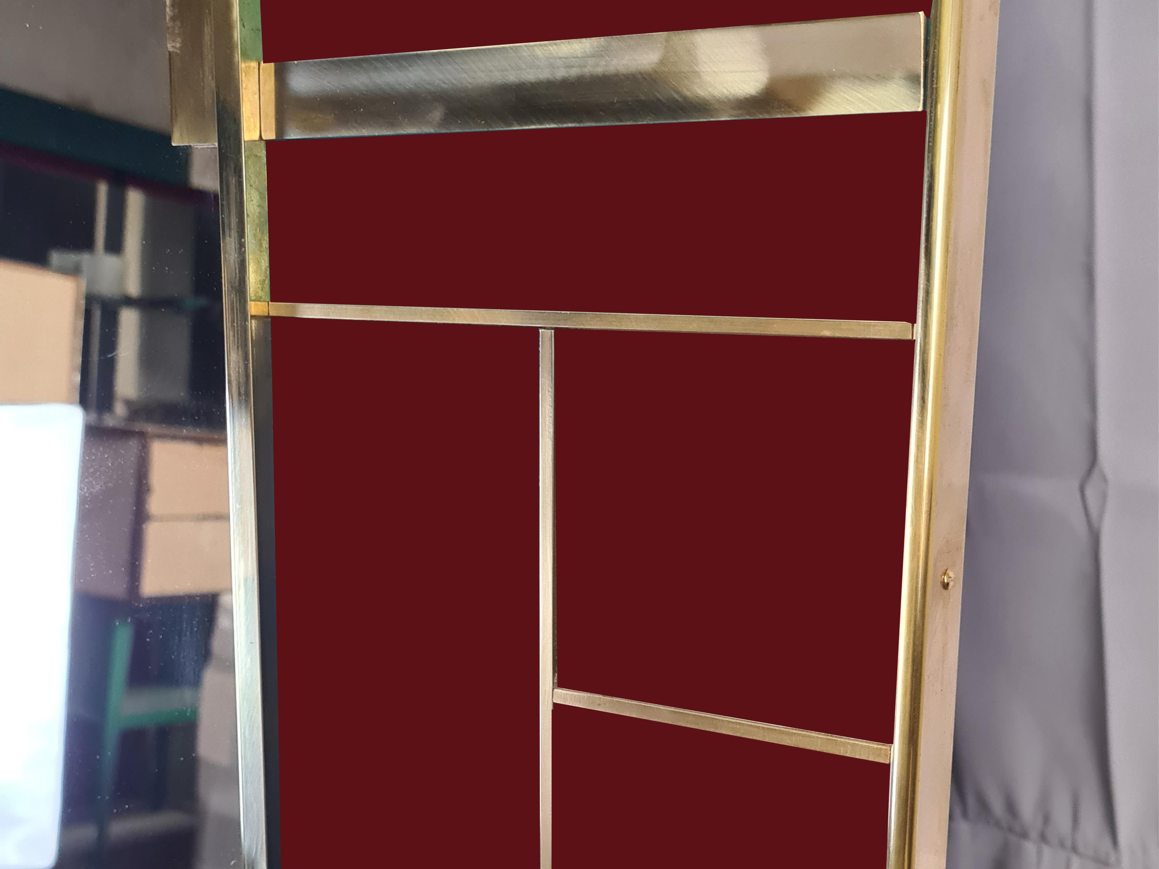 This exquisite Cartier red Murano glass mirror, made in Italy, embodies modern elegance with its Murano glass panels painted and carved in hand-squared shapes. 

The mirror's design is accentuated by elegant brass accents and a polished solid brass