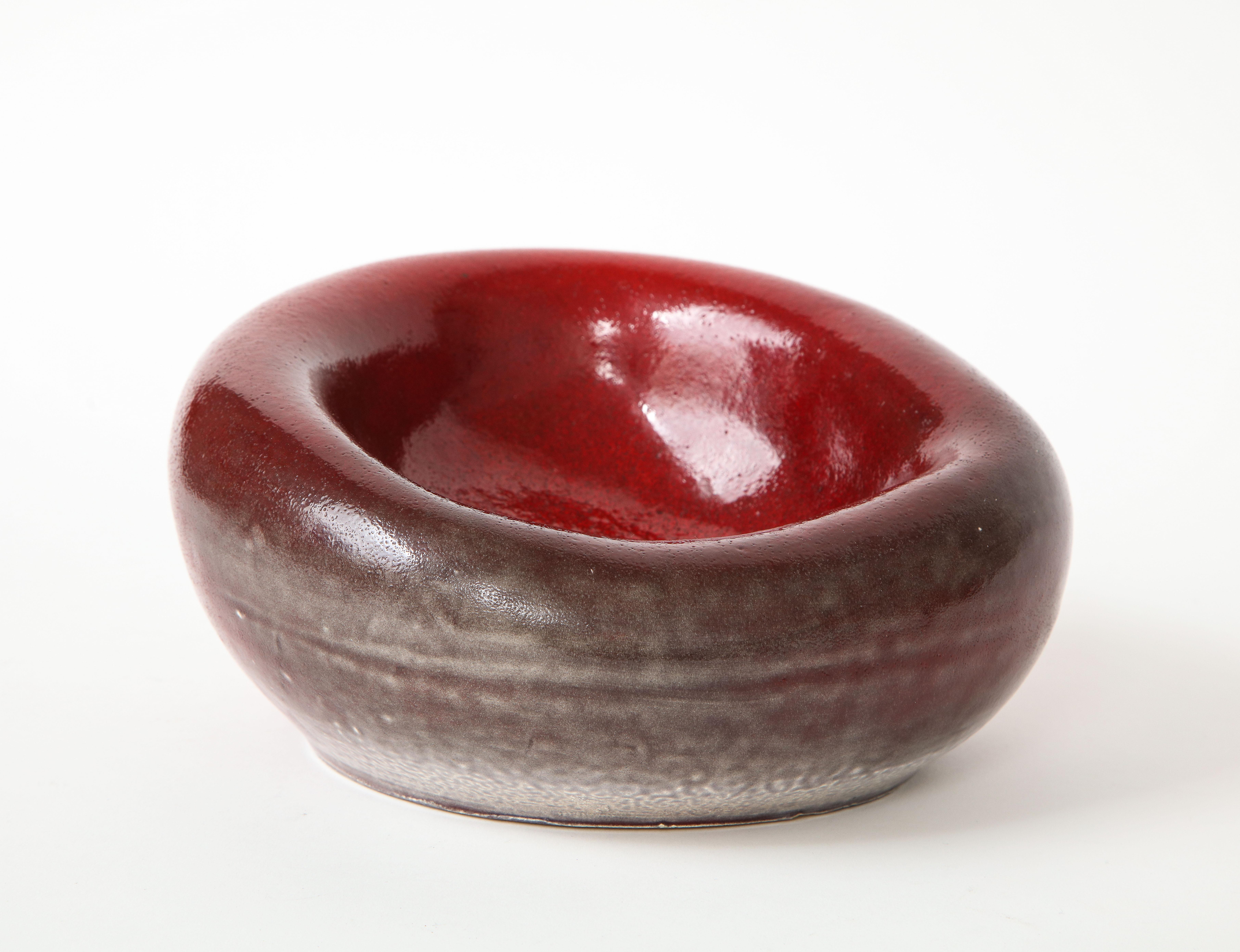 Stunning red ceramic bowl in the manner of Denise Gatard, France, c. 1960s.

Elegant free-form bowl executed in deep glazed red with crackle and mottled finishes.