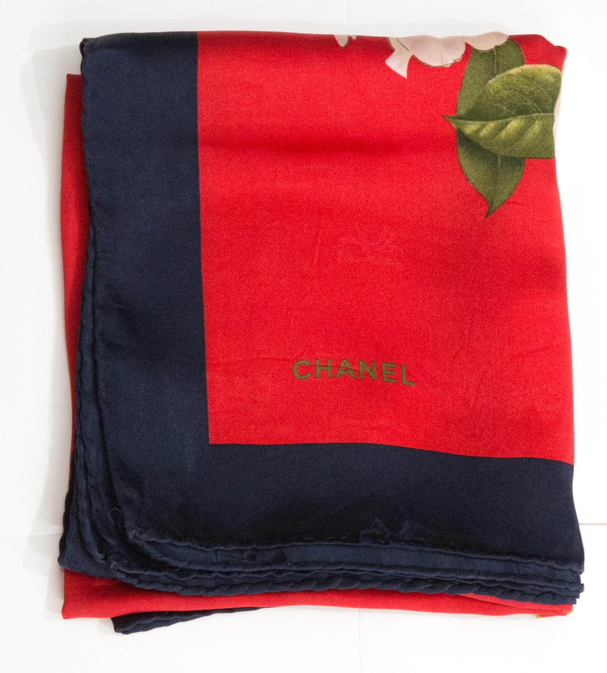 Chanel red silk scarf featuring a navy border, a flowers motives, a jacquard ground, a top logo signature. 
Circa 2000s  89cm X 89cm. 
Circa 2000s
Composition: 100% silk. 
In good vintage condition. Made in France.
34.6in. (88 cm) X 34.6in. (88