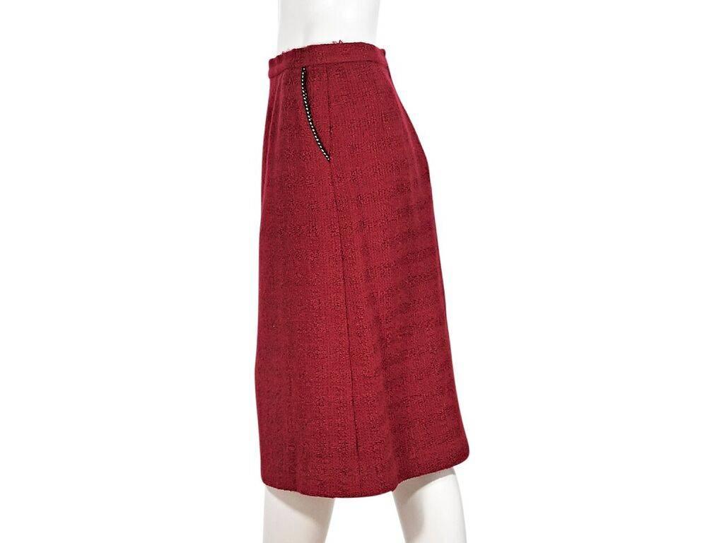 Product details:  Red wool skirt by Chanel.  Banded waist.  Waist slide pockets.  Concealed back zip closure.  28