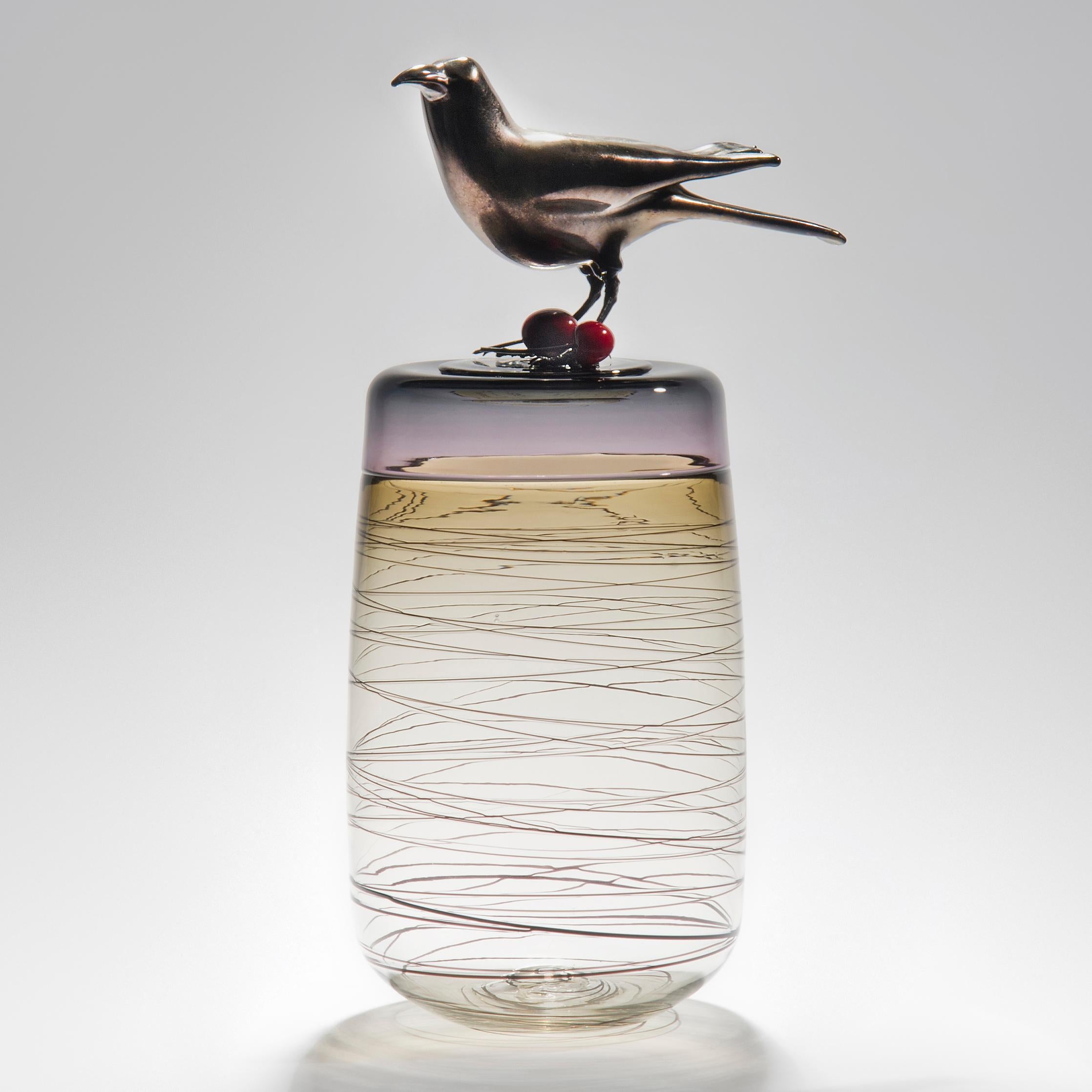 Red Cherries, is a hand blown art glass vase in olive with removal lid adorned with a hot sculpted black glass crow with red cherries by the British artist Julie Johnson. The crow figurine can also be lifted off with the main body leaving a