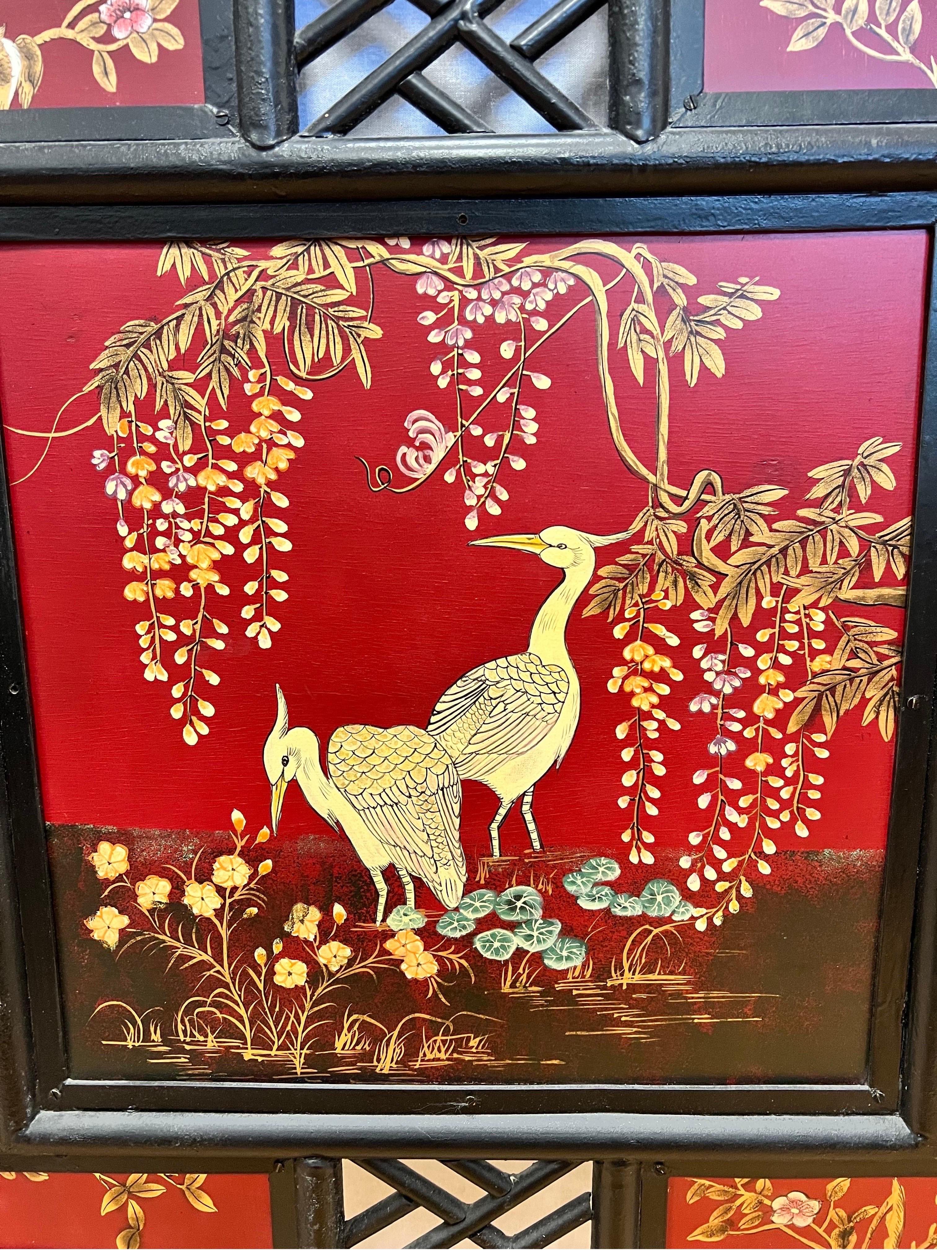 Exquisite Chinese fireplace screen with a black lacquered bamboo frame inset with panels of handpainted cranes and flowers on a brilliant red background.