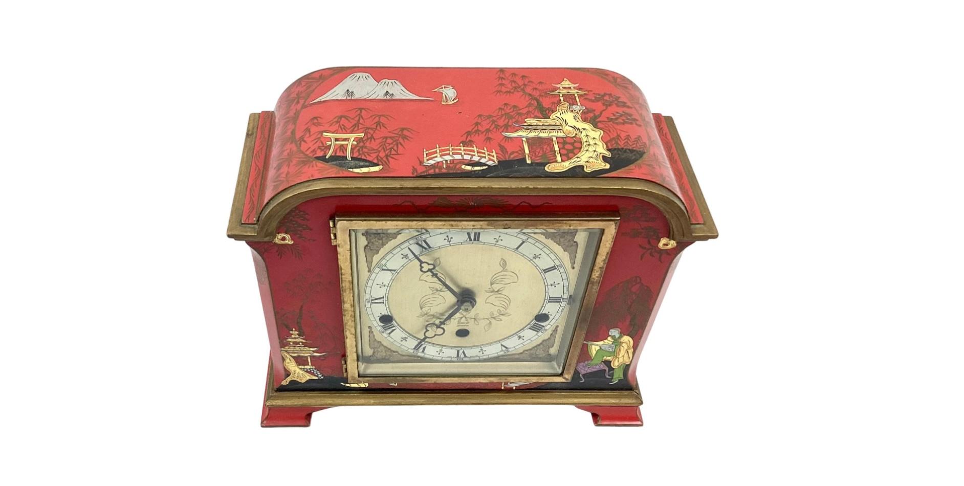 Red Chinoiserie decorated mantel clock, early to mid 20th century. Decorated with embossed Chinese garden scenes with figures, pagodas, and trees. Clock face is signed with 'Elliot London'. Back workings of clock stamped: 
