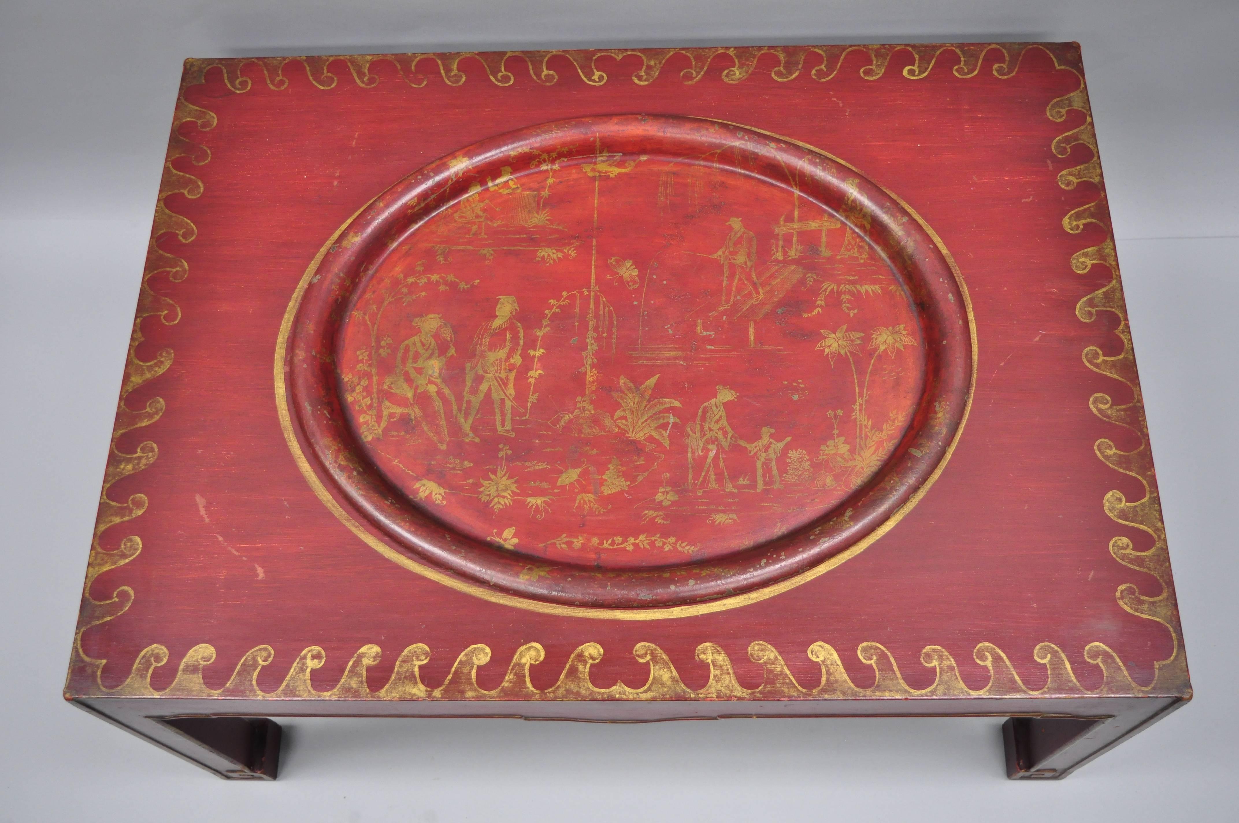 Vintage red chinoiserie oriental coffee table with removable tole metal serving tray. Item features an oval tole metal serving tray, red and gold distressed finish, solid wood frame, hand painted gold gilt details and scenes, great style and form,