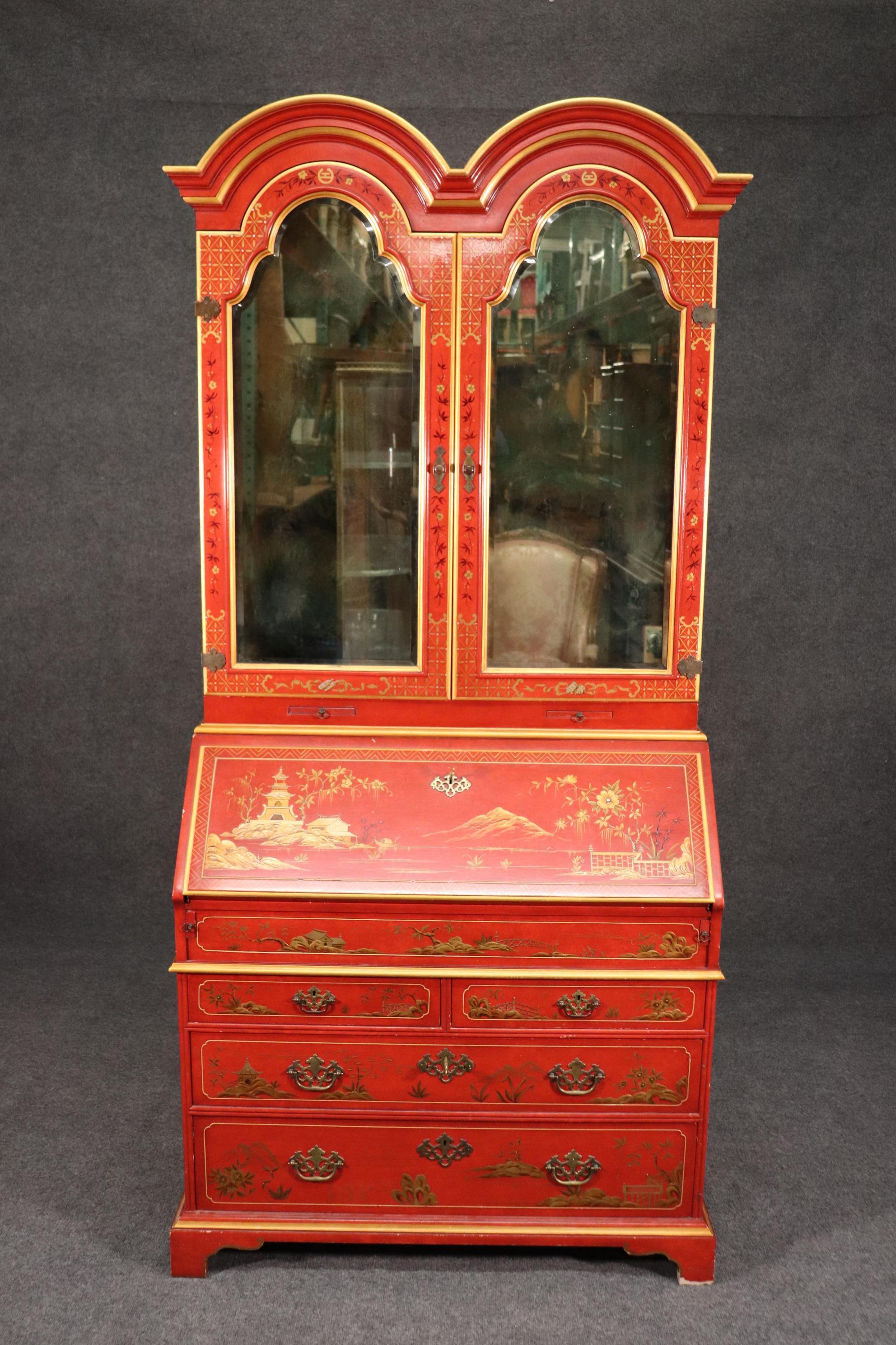 This is a beautiful red chinoiserie paint decorated secretary desk by John Widdicomb. The desk features beveled glass mirrored tombstone doors and a nice rare color. The desk is in good vintage condition and will show signs of use and some minor