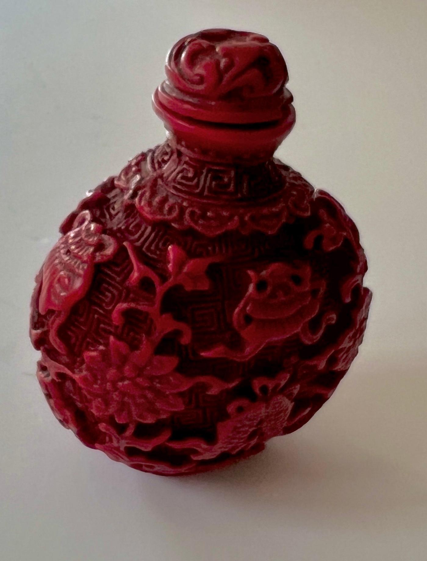 A beautiful cinnabar snuff or fragrance box.  The piece could be used for perfumes, snuff, or purely decorative.

The intricate hand-carved detailing and color make this a very special piece.  a complement to any dressing table, desk or work staton.