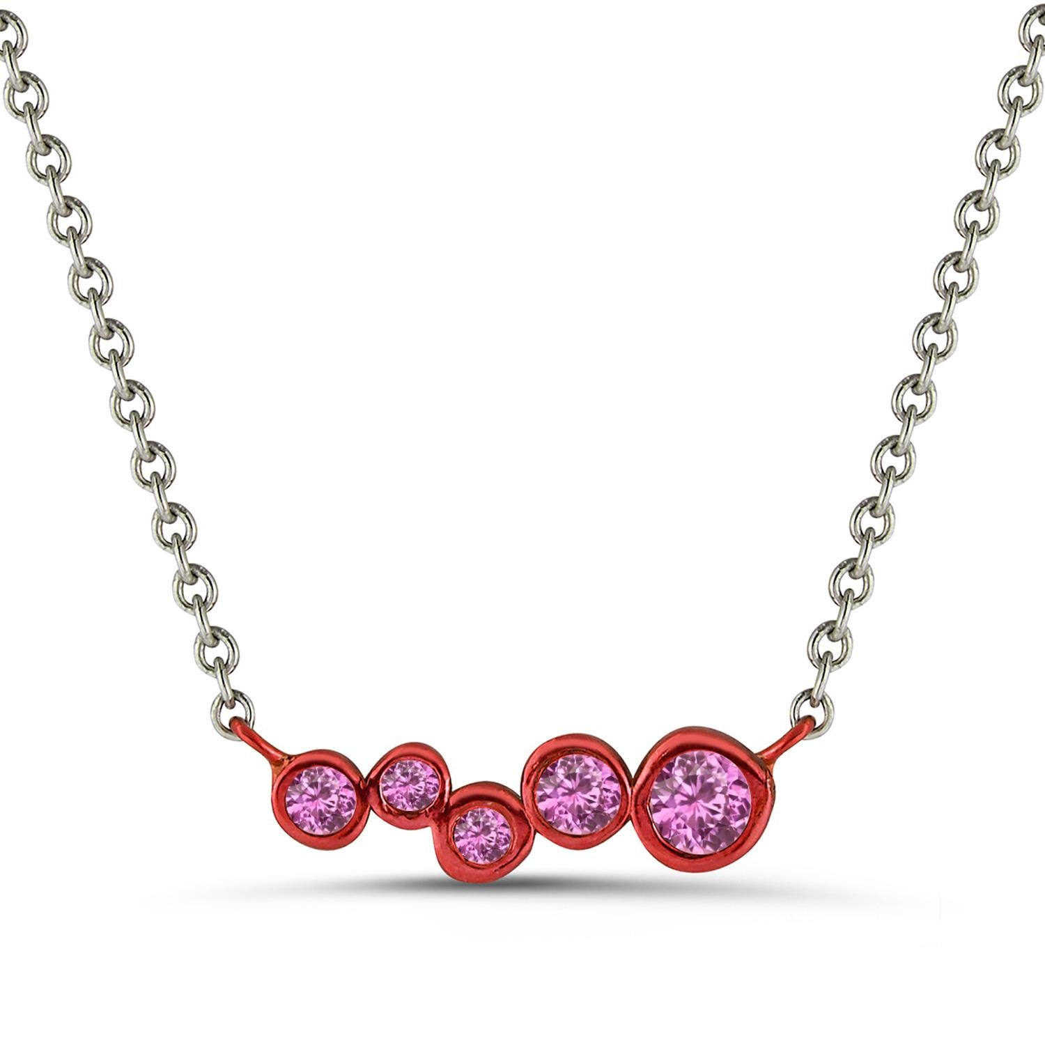 Hi June Parker's version of the classic bar pendant sprinkled with tapering sizes of Pink Sapphires ceramic plated with Bright Red to add a pop of electric color to your neck.

Inspired by seeing the cross-section view of life, as if slicing a tree
