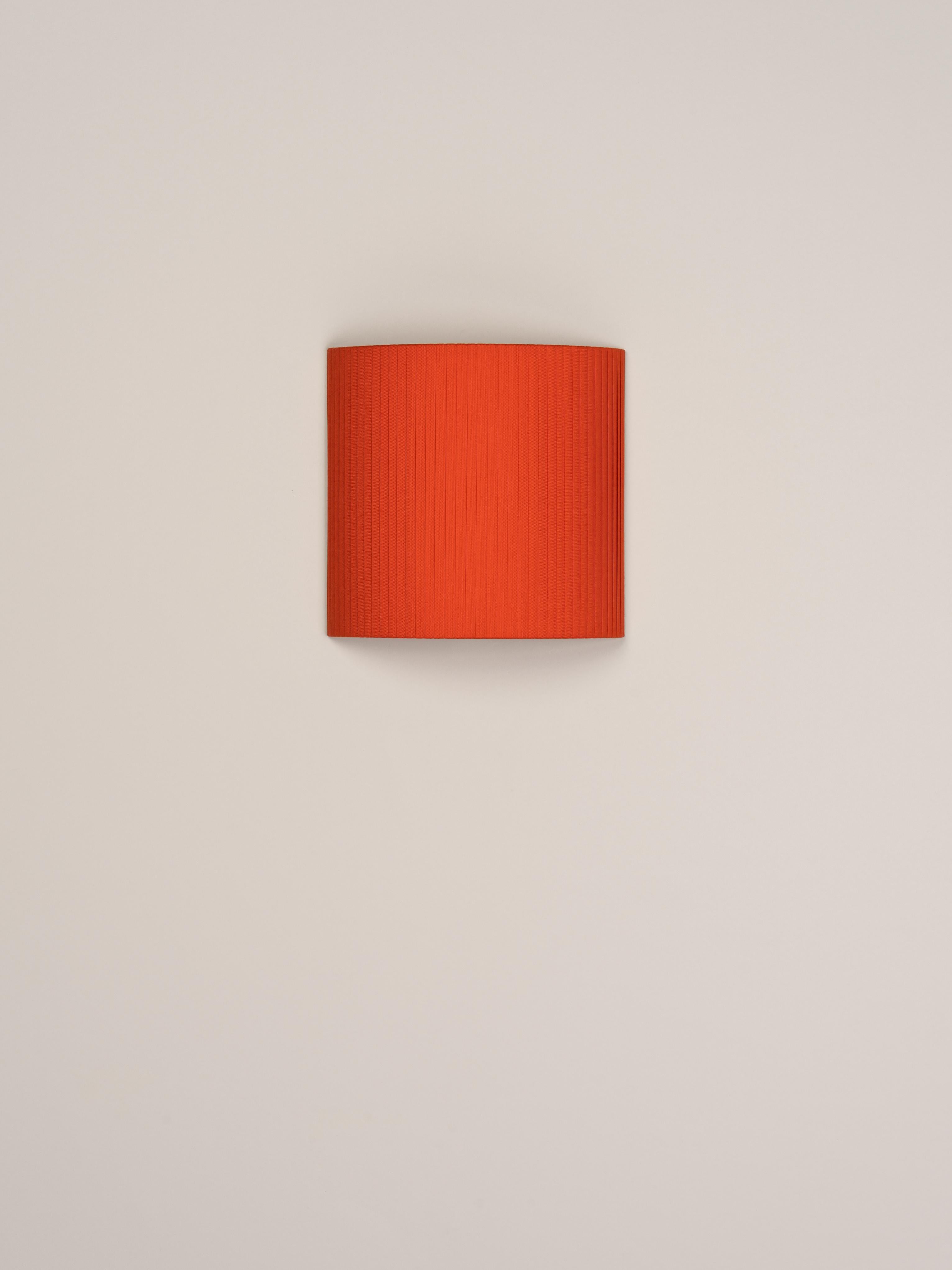 Red comodín cuadrado wall lamp by Santa & Cole
Dimensions: D 31 x W 13 x H 30 cm
Materials: Metal, ribbon.

This minimalist wall lamp humanises neutral spaces with its colourful and functional sobriety. The shade is fondly hand-ribboned, piece
