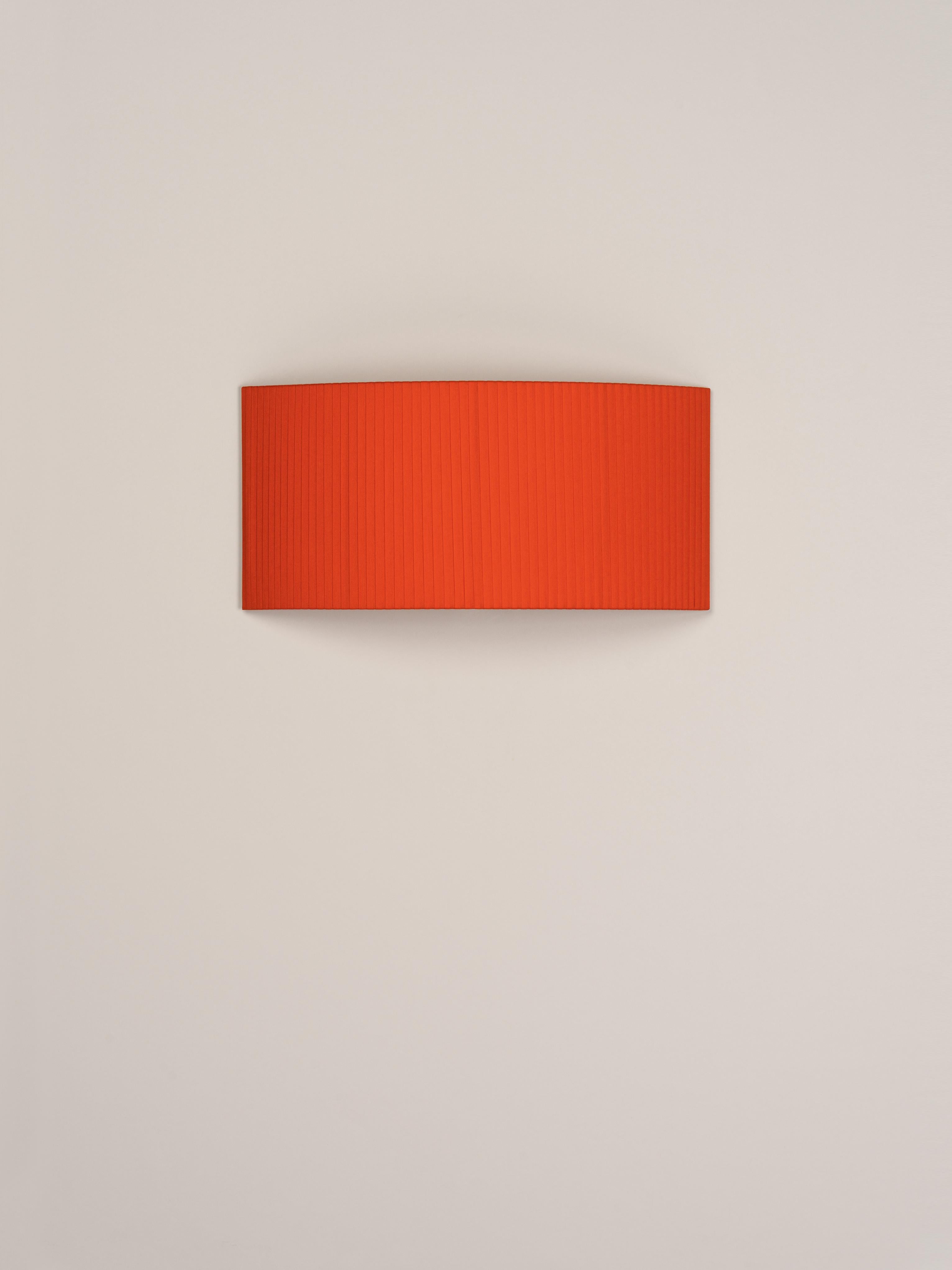 Red Comodín Rectangular wall lamp by Santa & Cole
Dimensions: D 50 x W 13 x H 24 cm
Materials: Metal, ribbon.

This minimalist wall lamp humanises neutral spaces with its colourful and functional sobriety. The shade is fondly hand-ribboned,