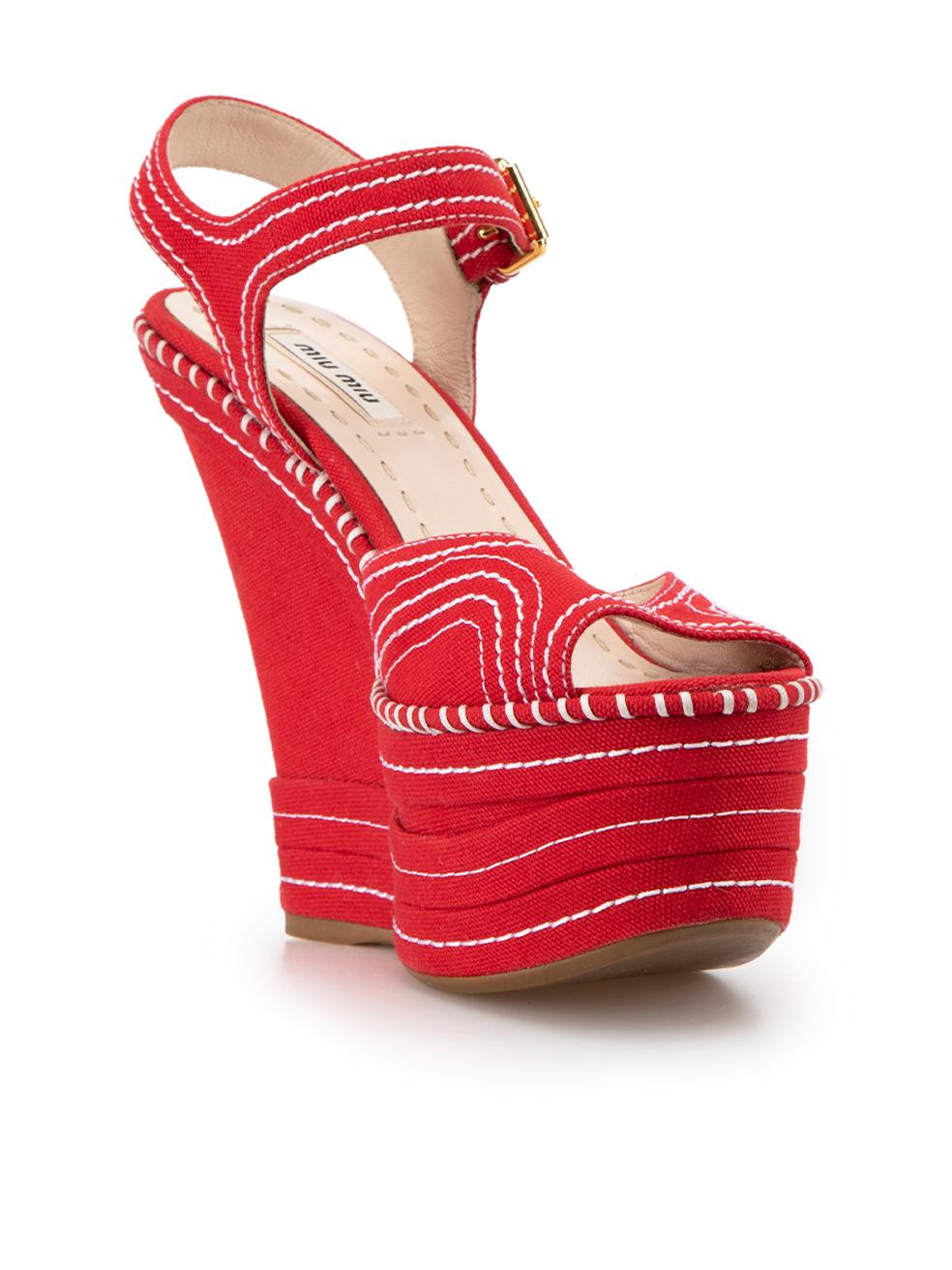 CONDITION is Very good. Minimal wear to shoes is evident. Minimal wear to the left shoe with small mark to the left-side on this used Miu Miu designer resale item.



Details


Red

Canvas

Platform wedge sandals

Peep-toe

White contrast