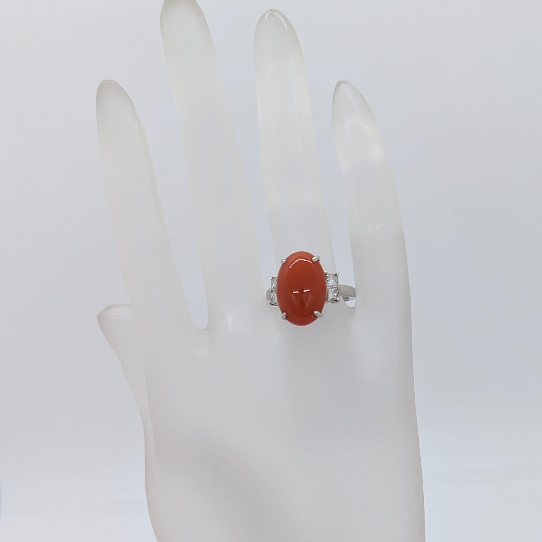 Wunderschöner ovaler Cabochon aus roter Koralle mit 0,46 ct. weißem und hellem Diamanten im Prinzessschliff von guter Qualität.  Handgefertigt in Platin.  Ringgröße 6,75+.